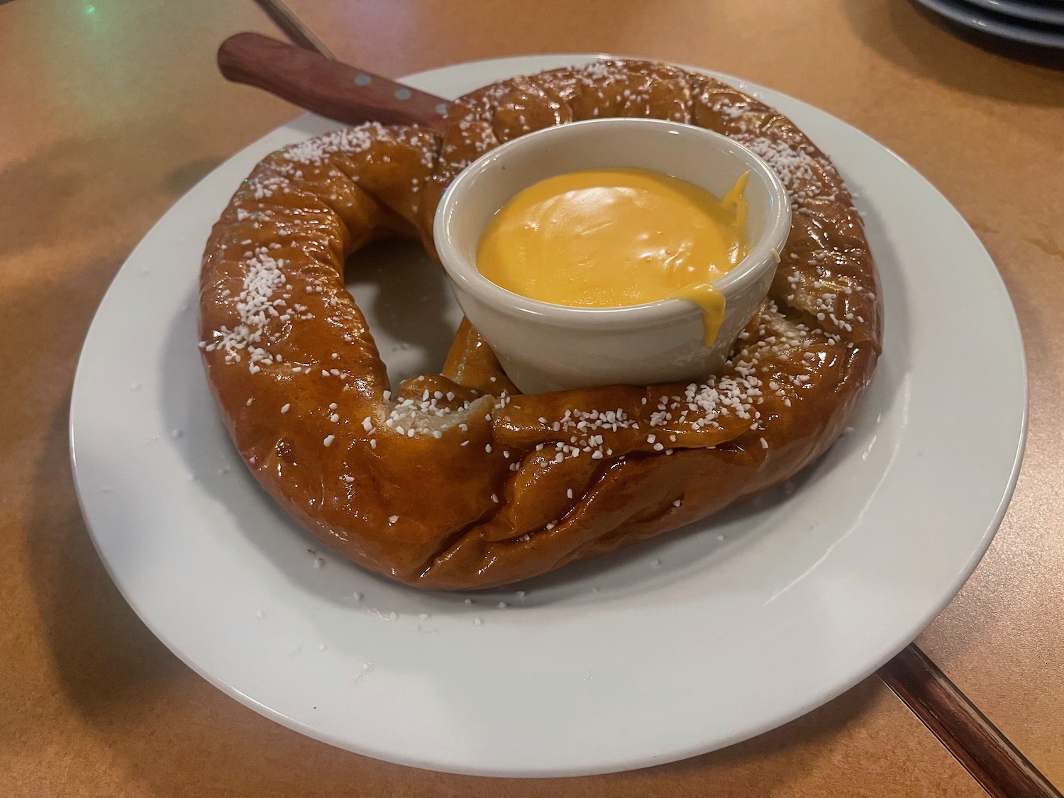 a pretzel with cheese sauce on a plate