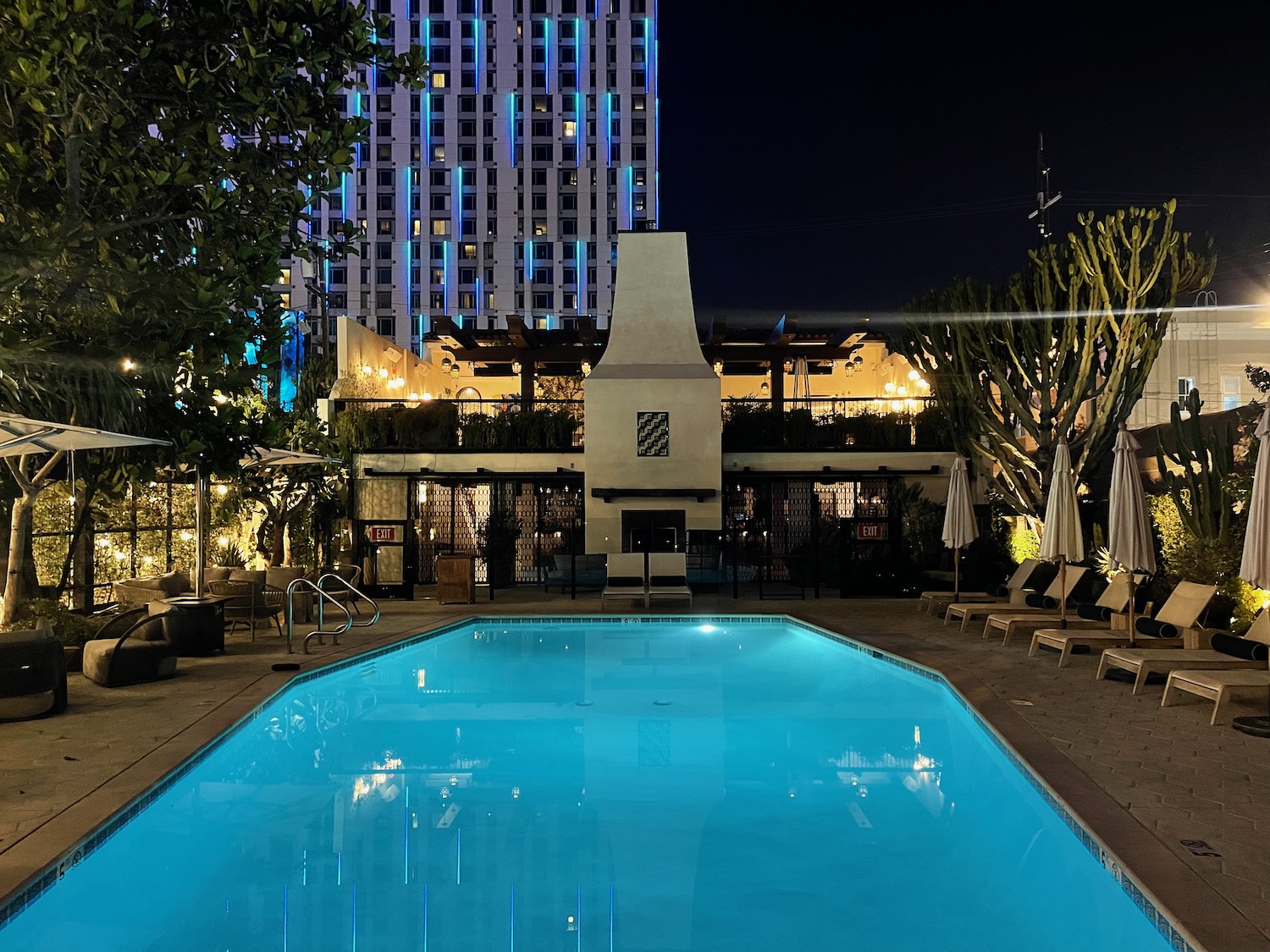 a pool with a fireplace and a building in the background