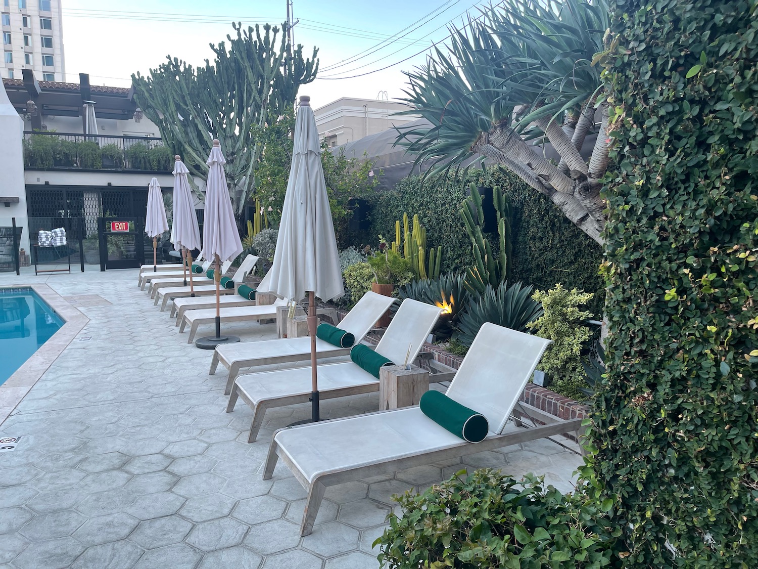 a group of lounge chairs and umbrellas on a patio