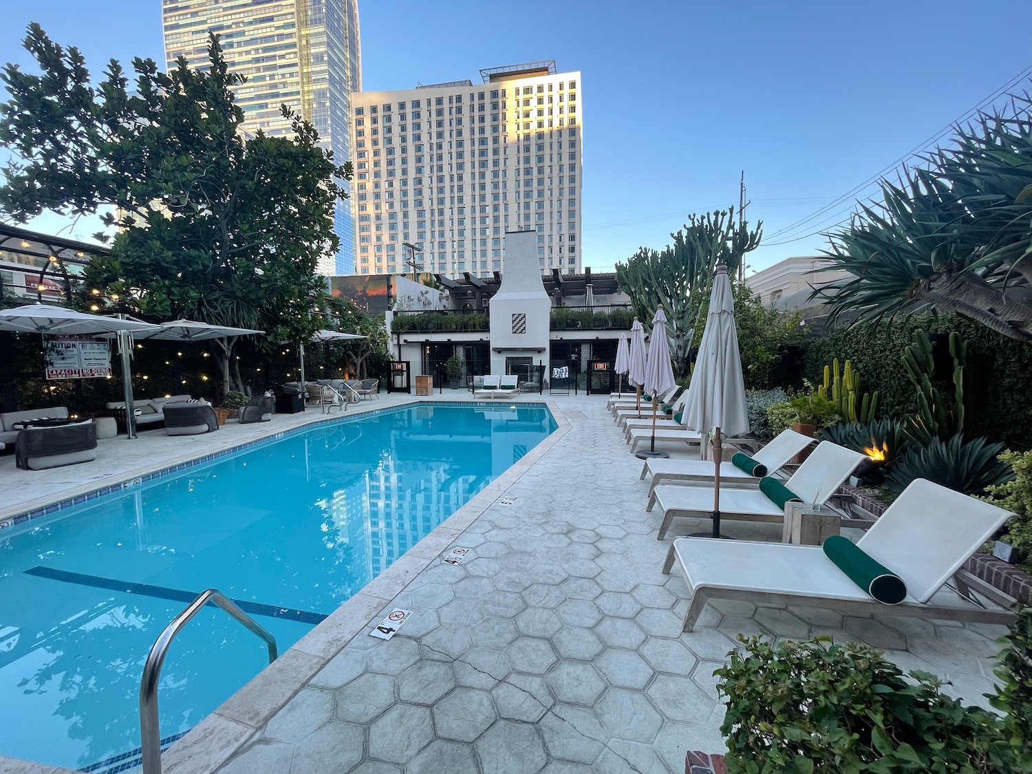 a pool with chairs and umbrellas in a hotel