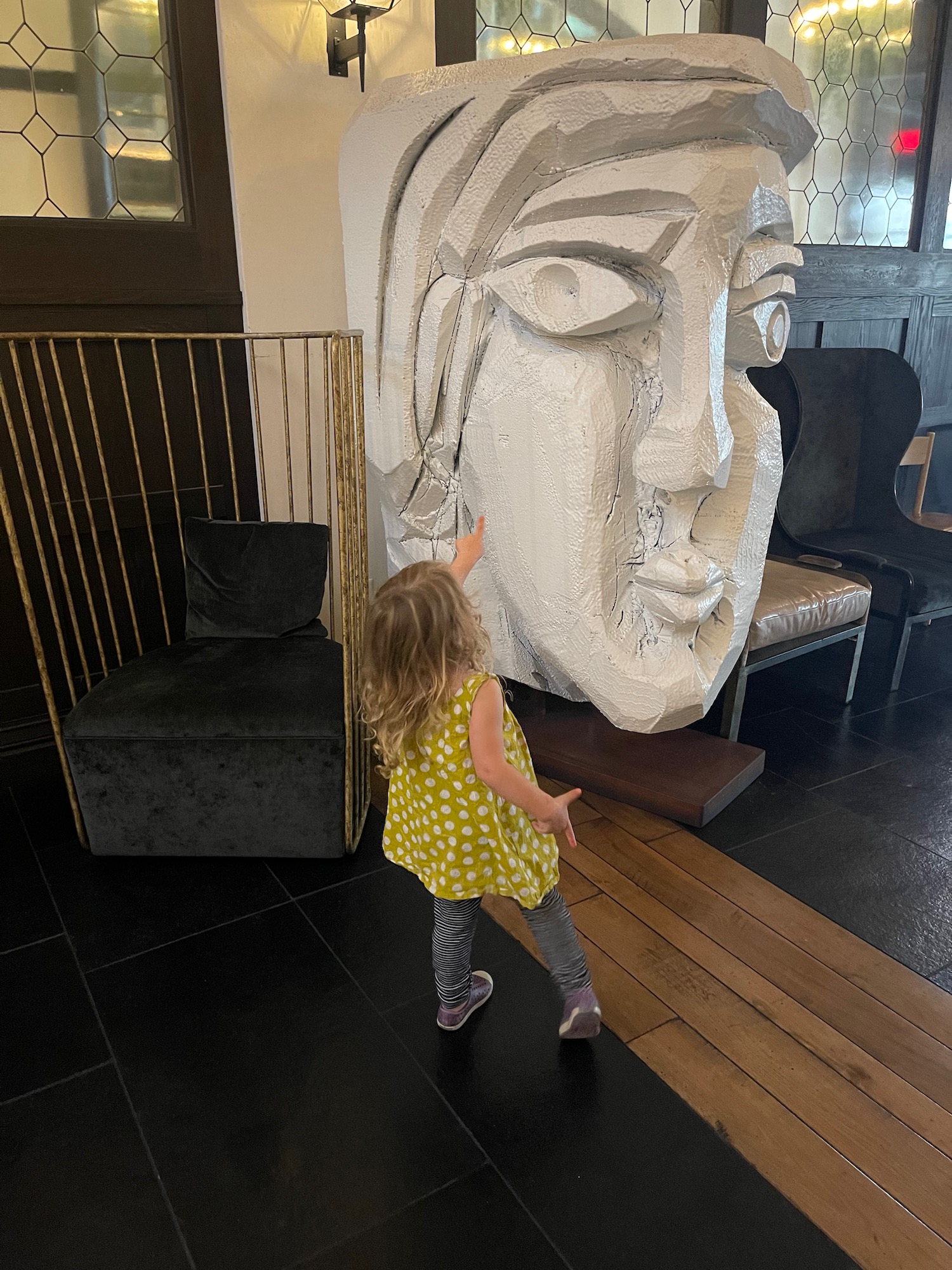 a girl pointing at a large sculpture