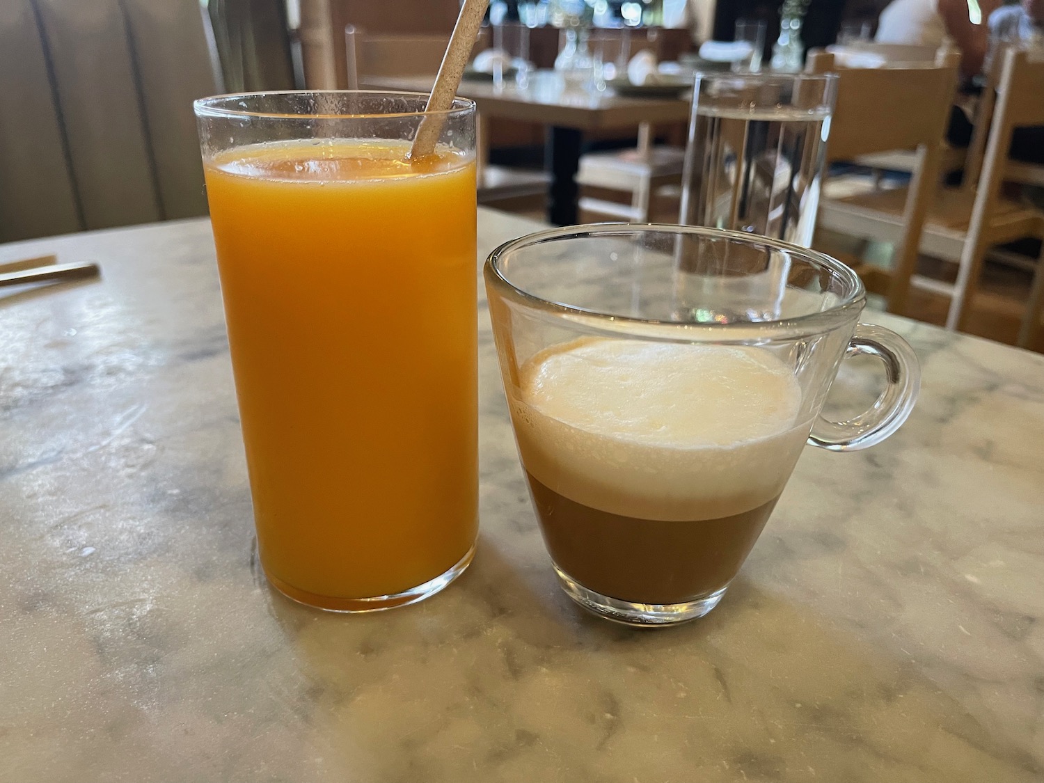 a glass of orange juice next to a glass of liquid