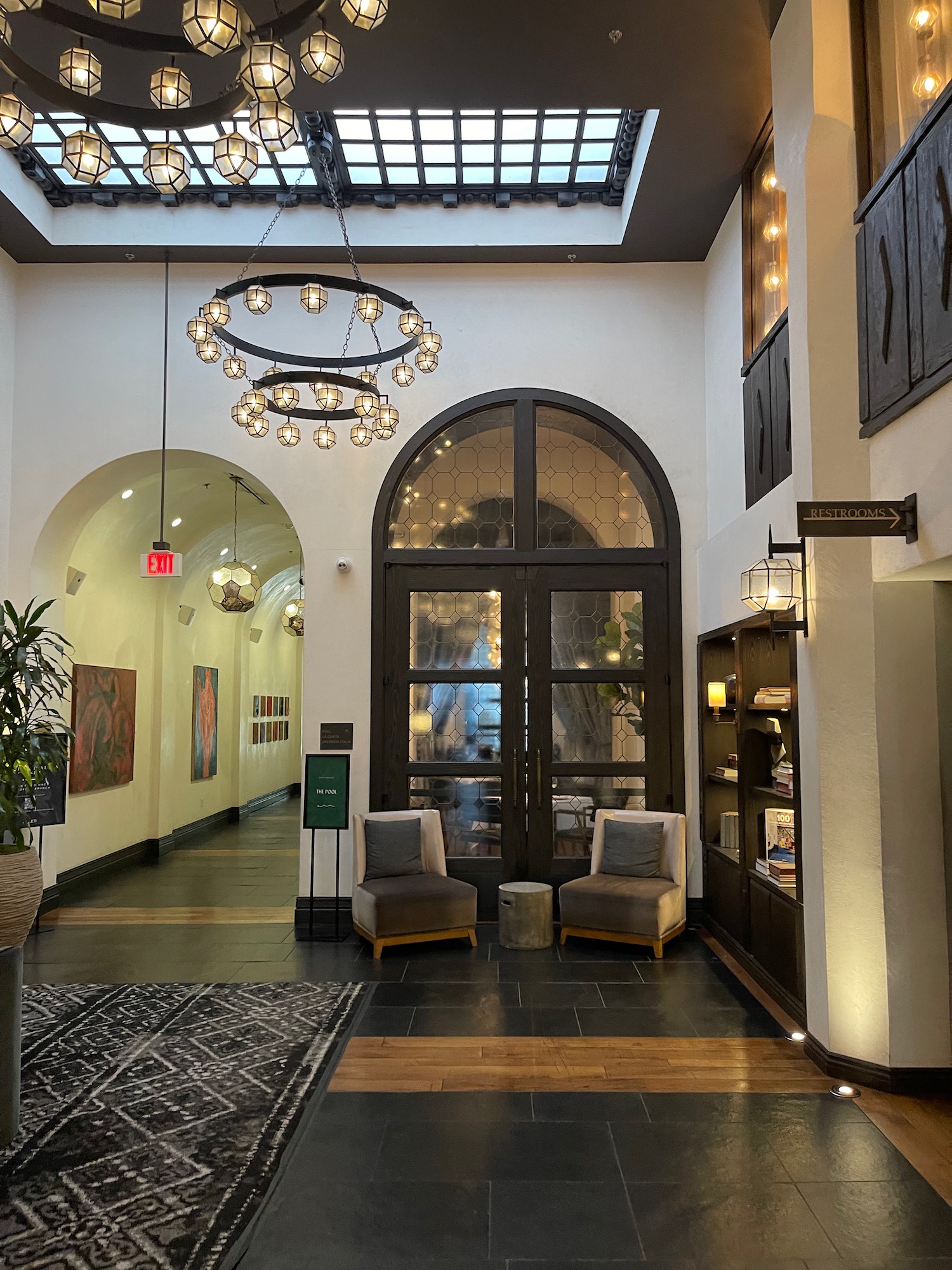 a hallway with a glass door and chairs