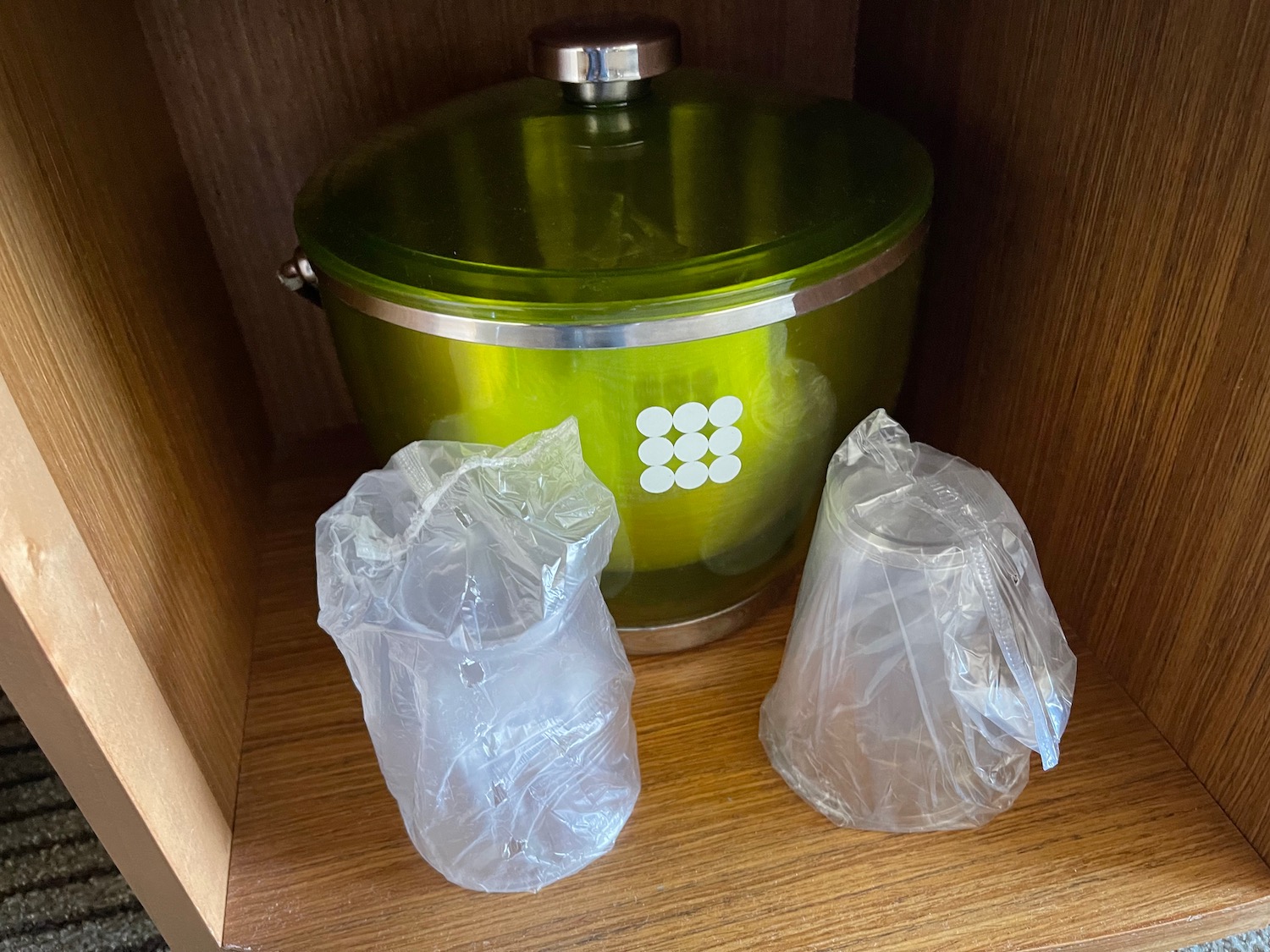 a green pot and plastic bags in a shelf
