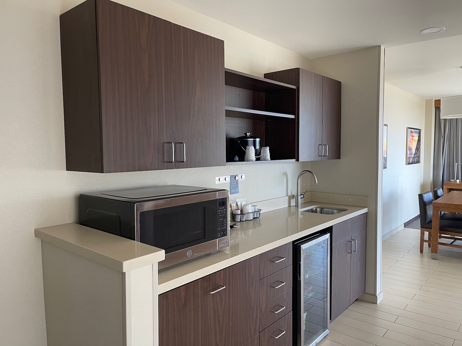 a kitchen with dark wood cabinets and a microwave