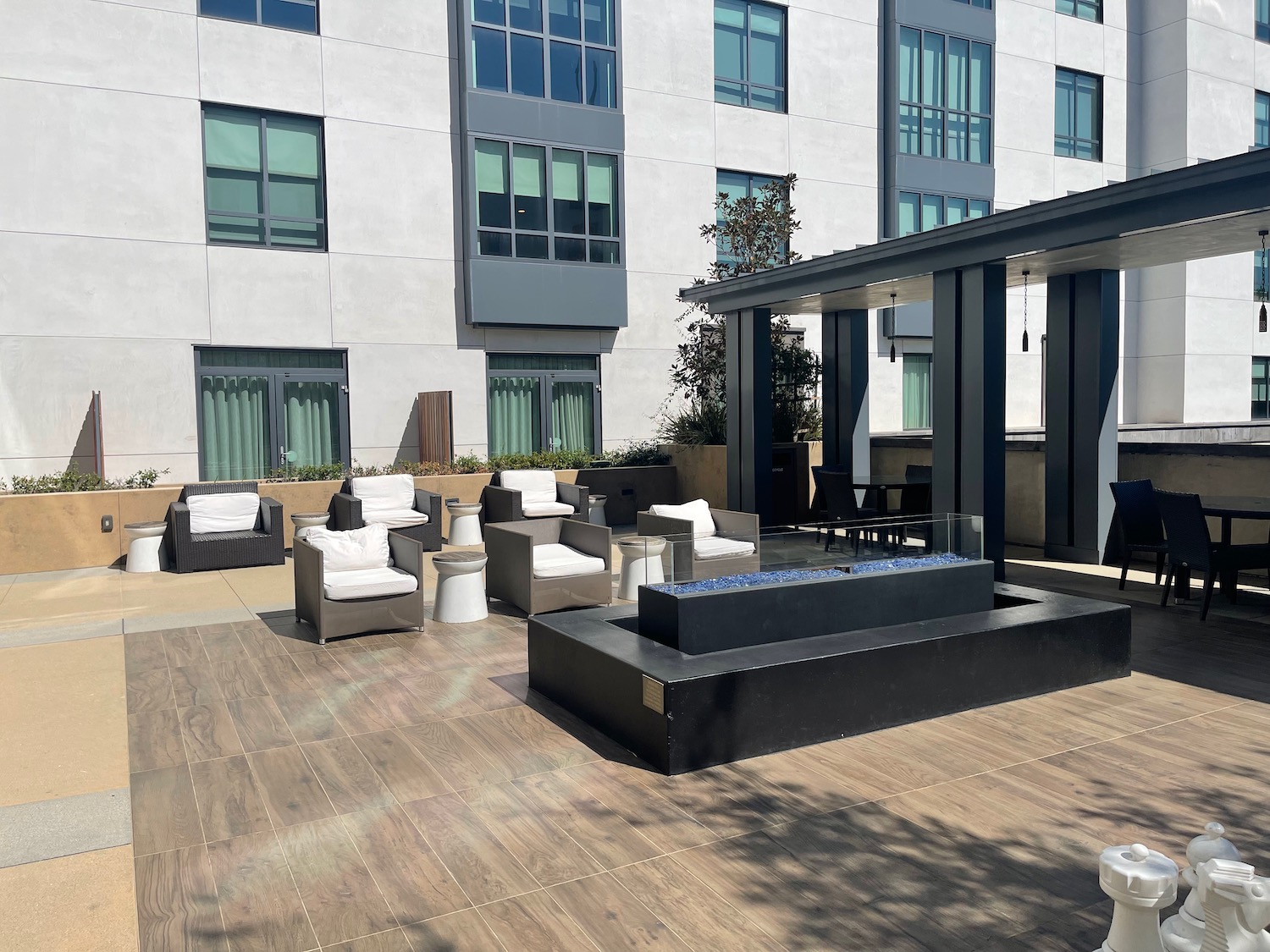 a patio with a fire pit and chairs