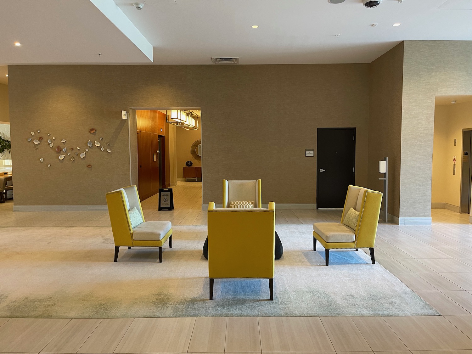 a room with yellow chairs and a white rug