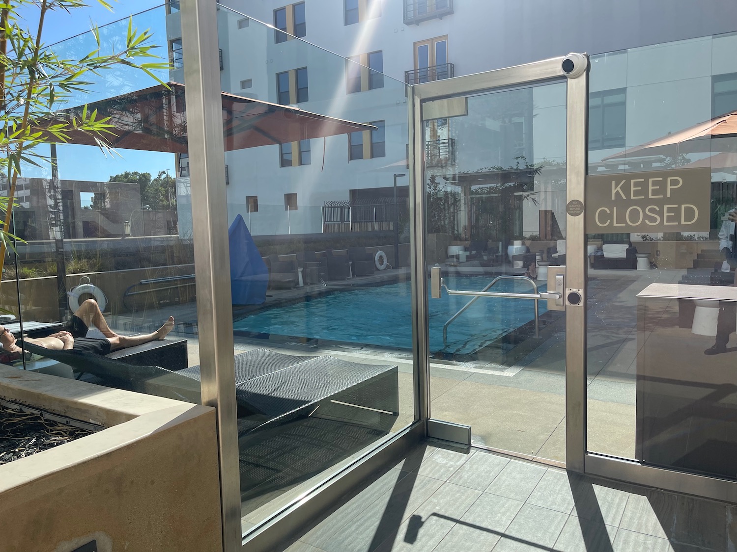 a person sitting on a bench by a pool