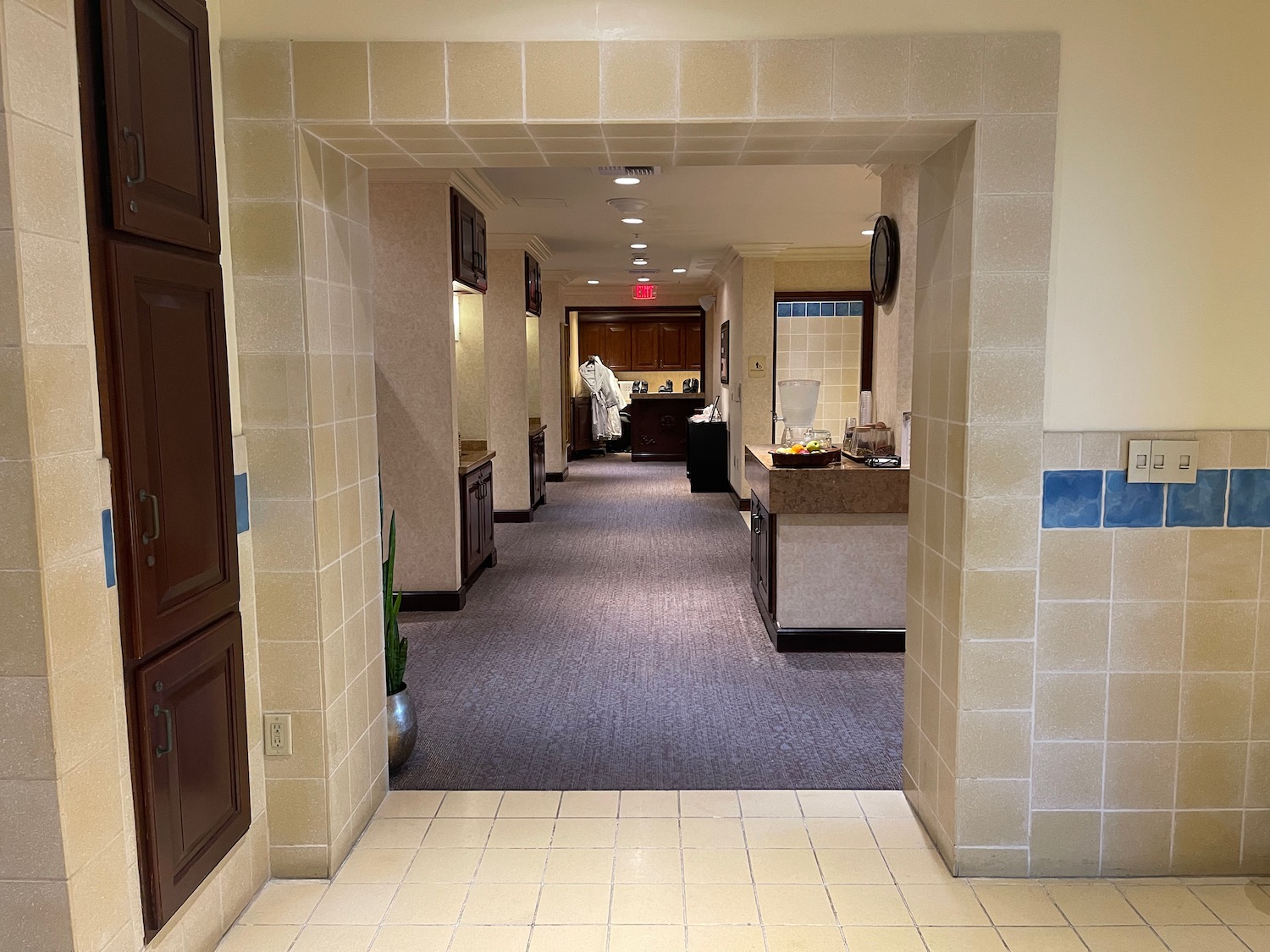 a hallway with a tile floor and a white wall