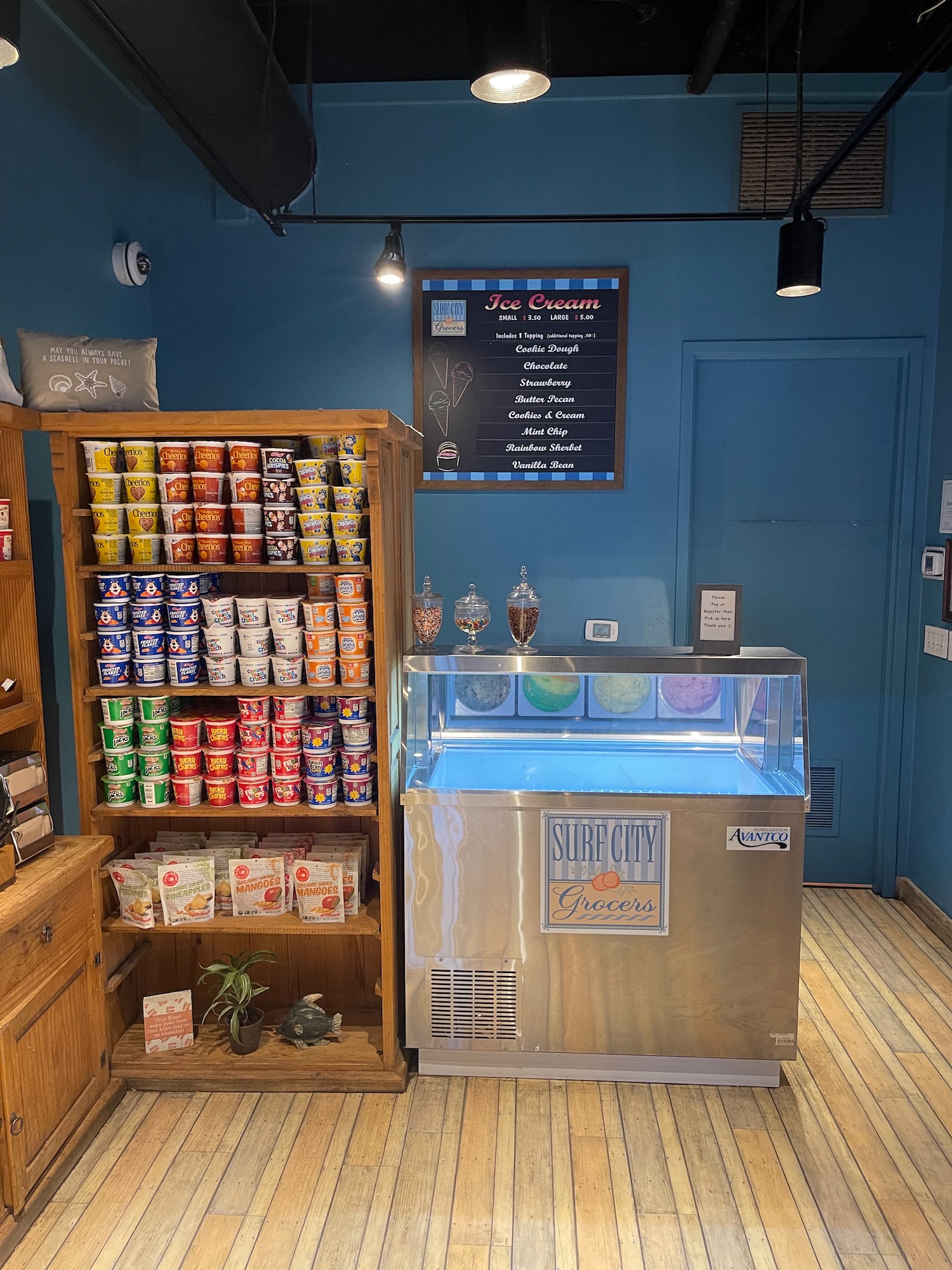a ice cream cooler and shelves in a room