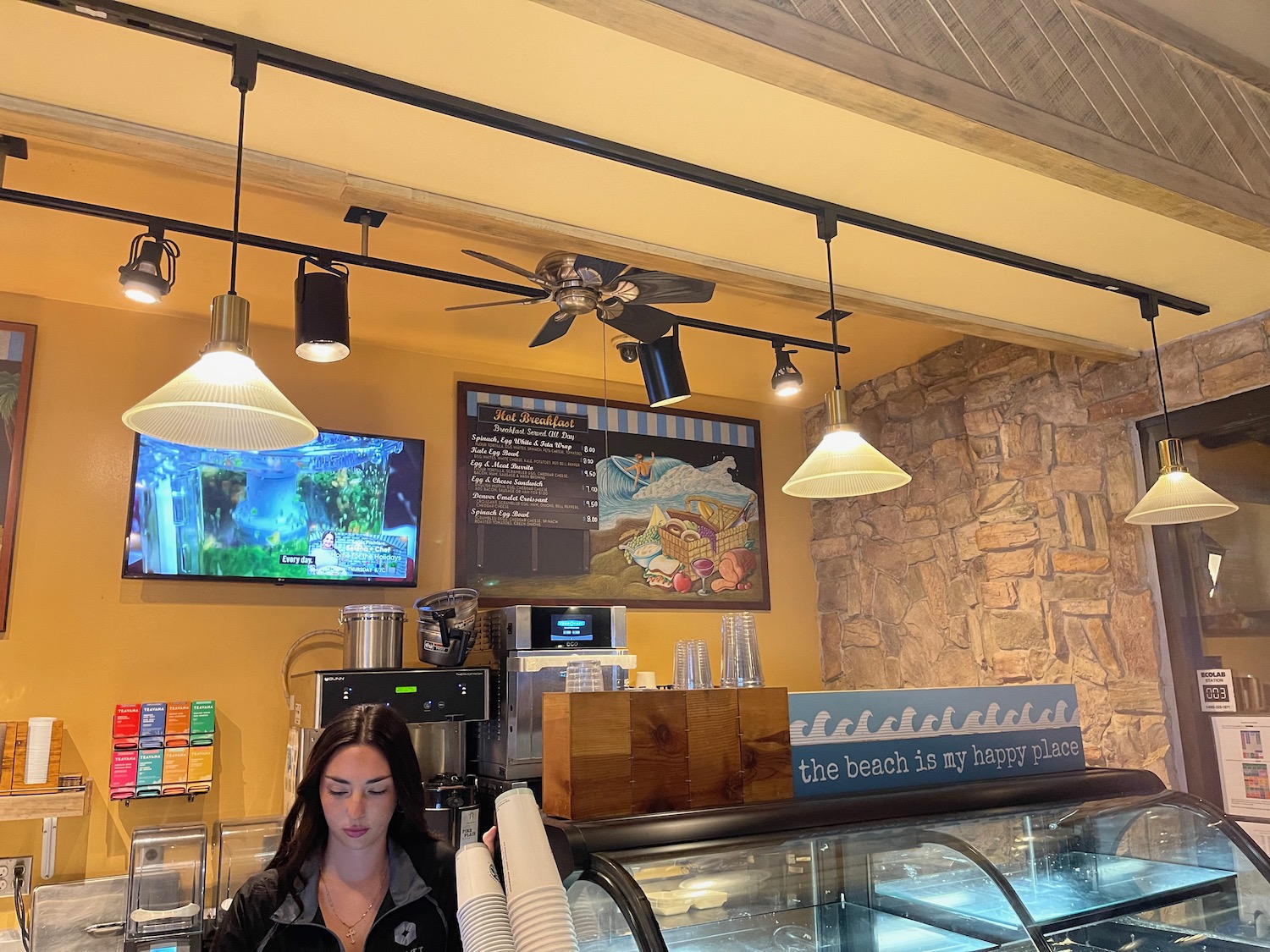 a woman behind a counter in a coffee shop