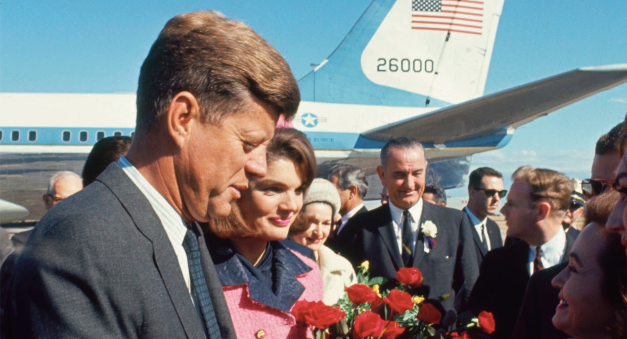 a man and woman standing next to a plane