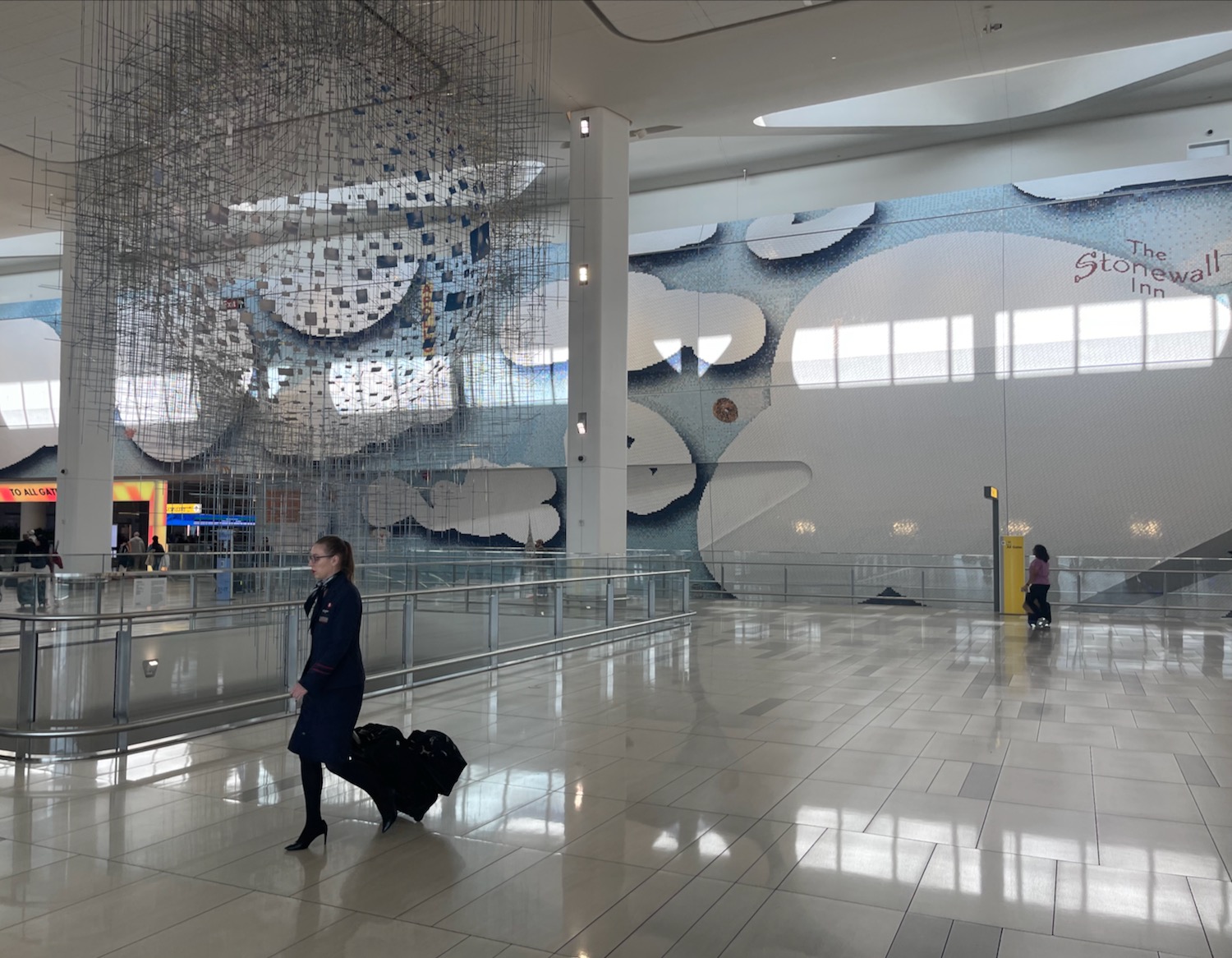 a woman walking in a large building with a large chandelier