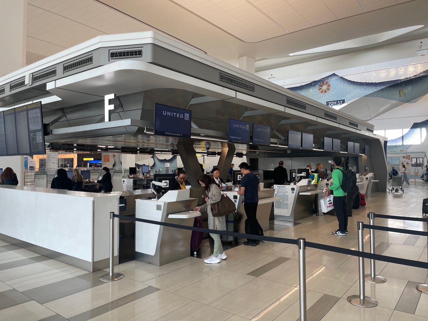 people standing in a line at an airport check-in counter