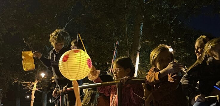 a group of children holding lanterns and a pole