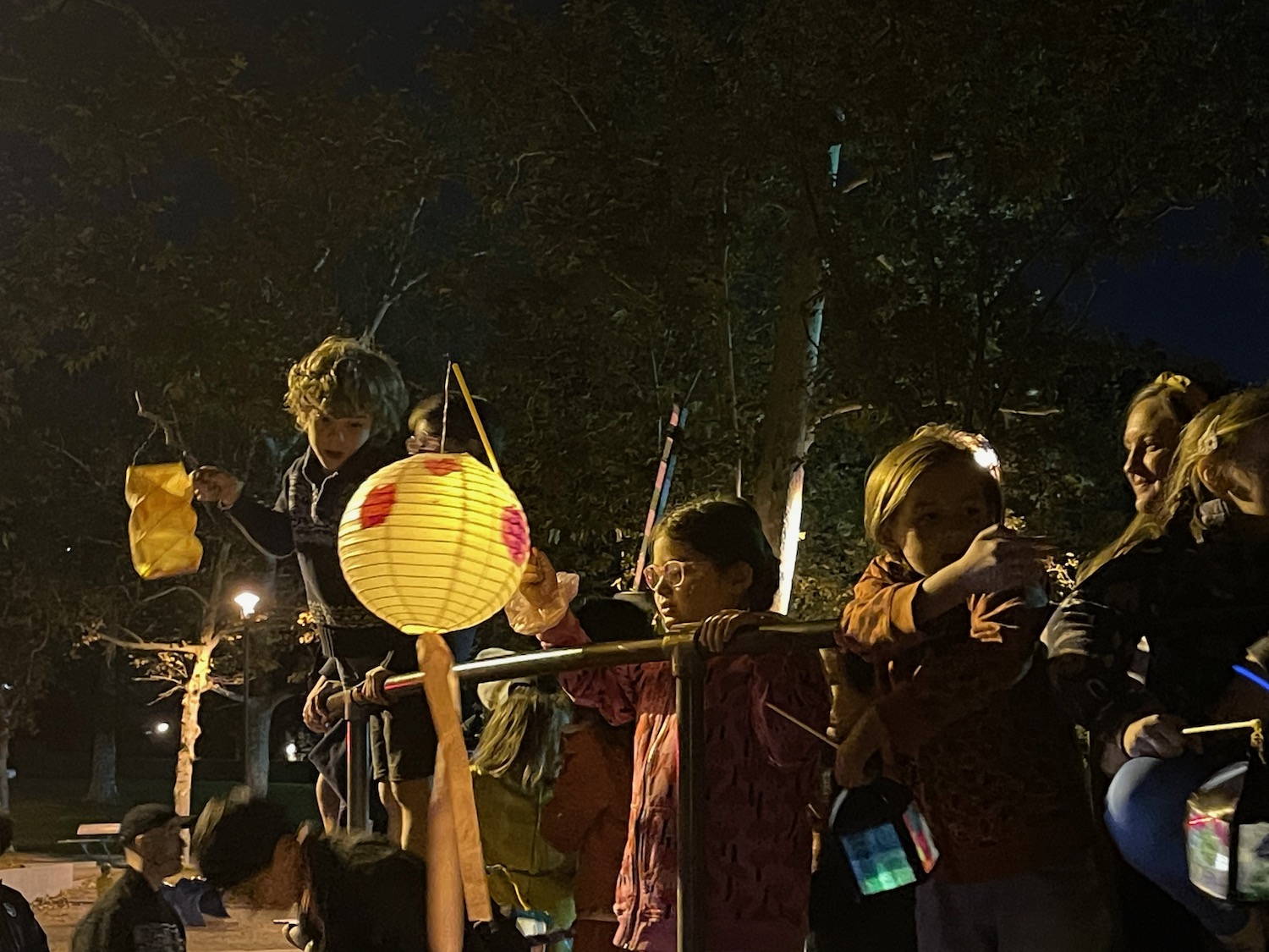 a group of children holding lanterns and a pole