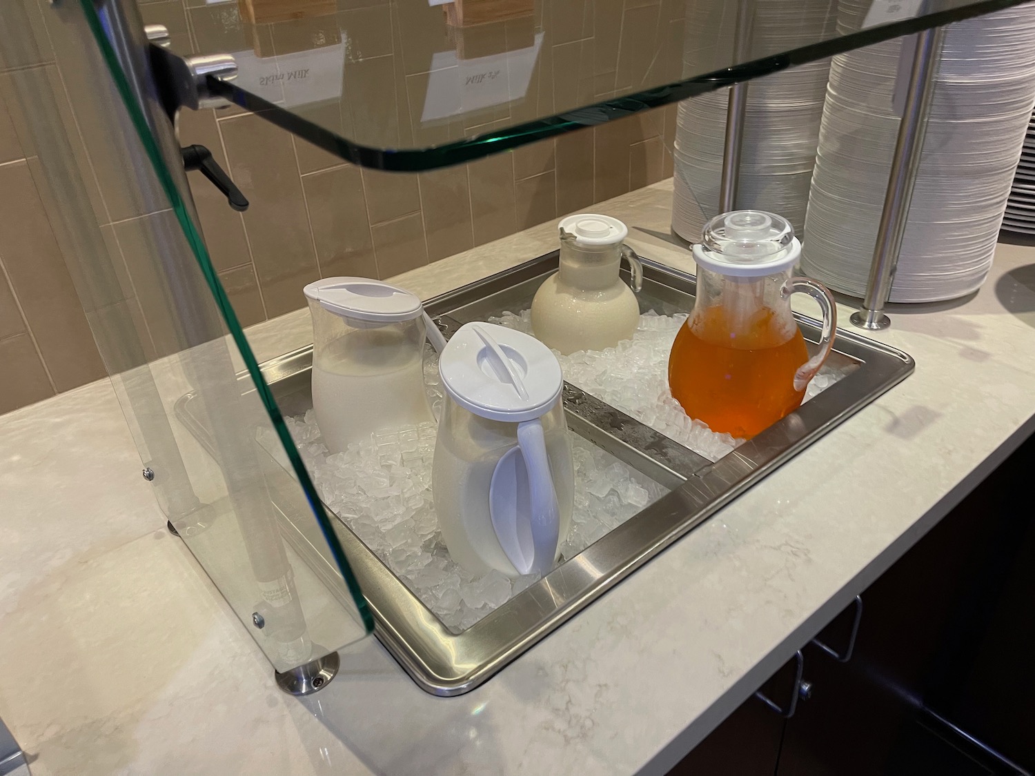 a glass display case with different types of milk in ice