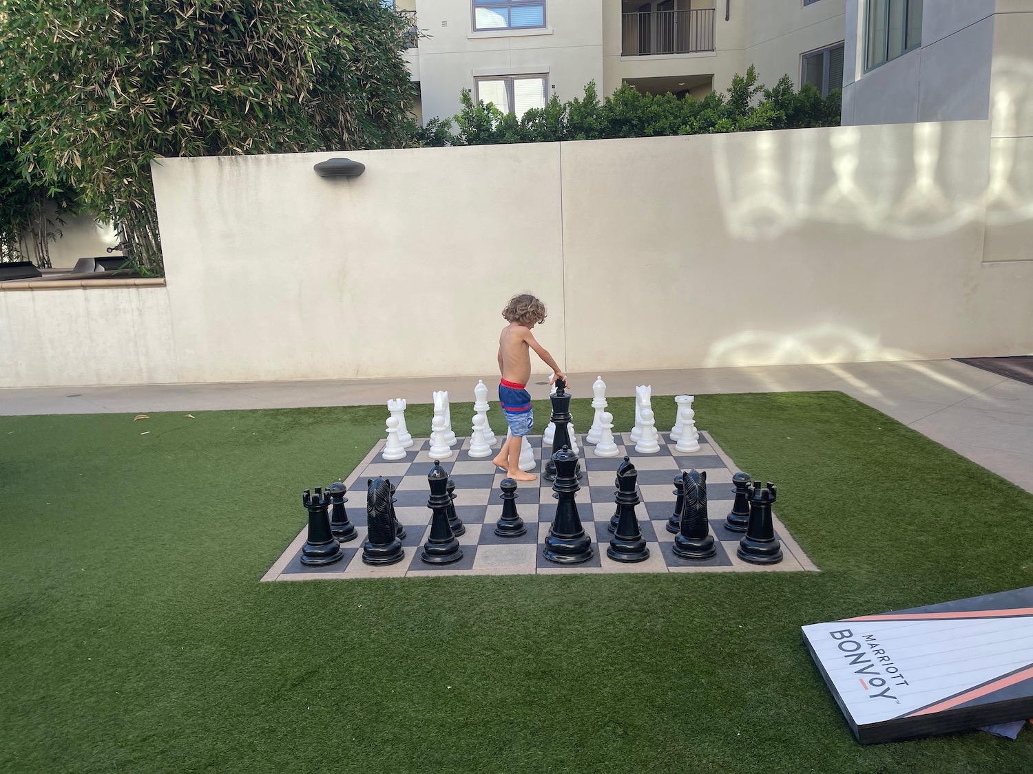 a boy standing on a chessboard