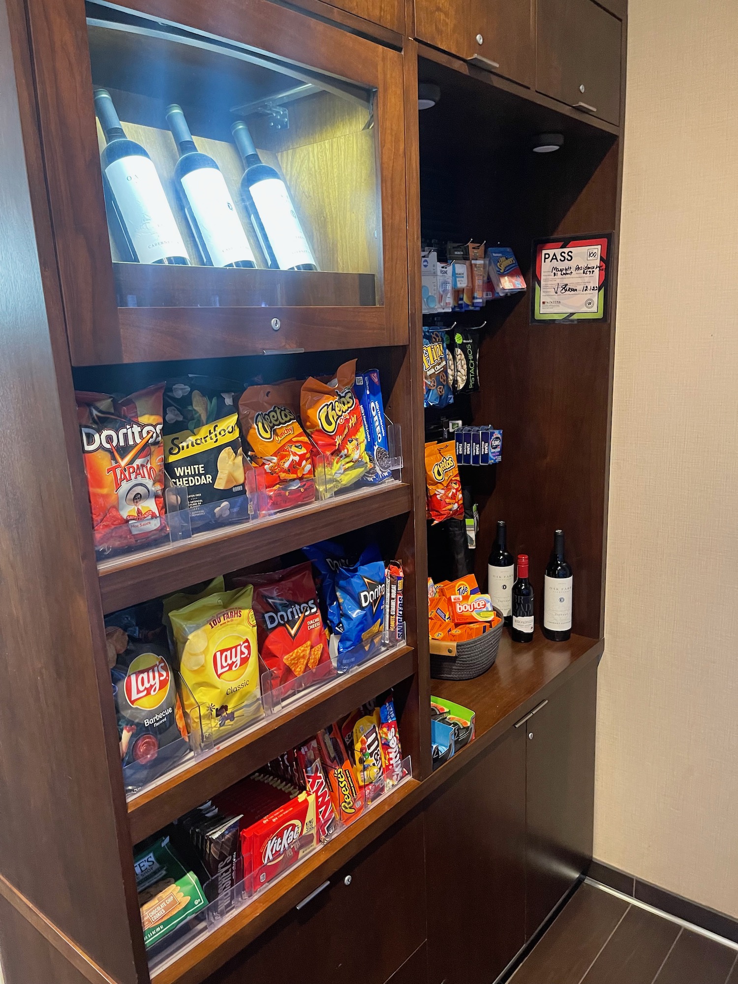 a shelf with snacks and wine bottles