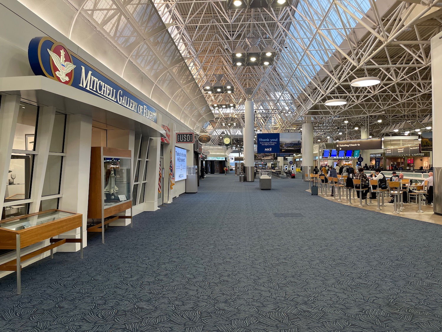 a large airport terminal with people walking around