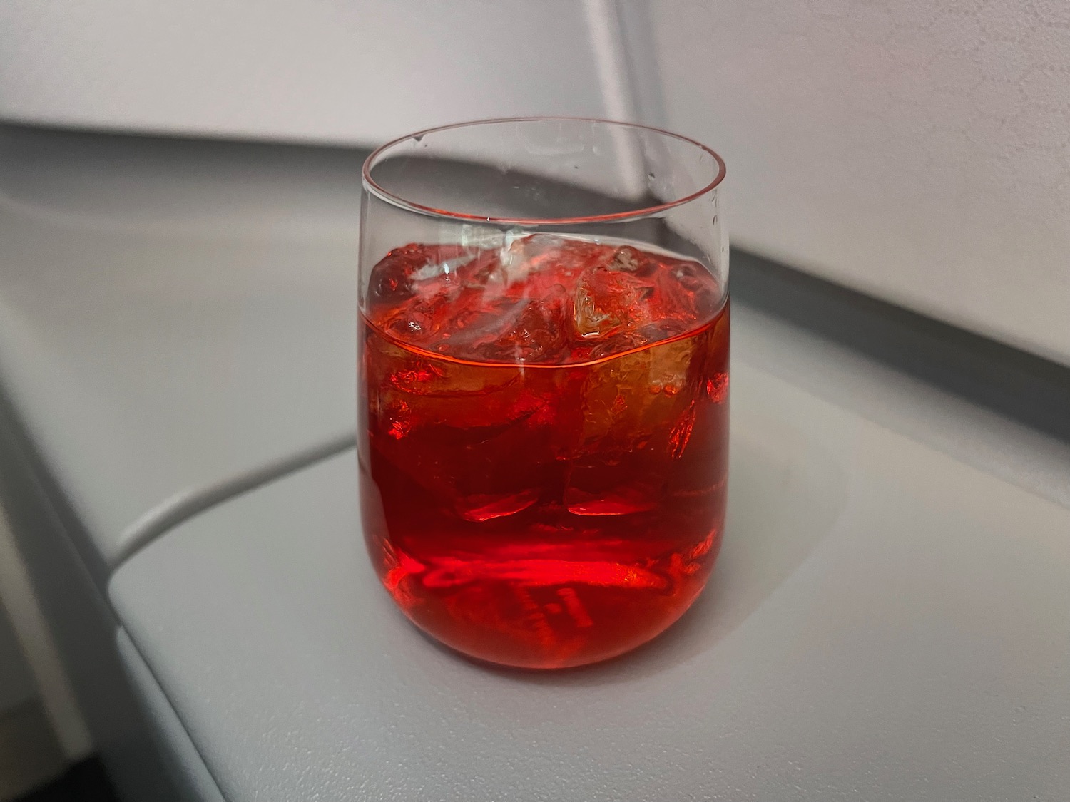 a glass of red liquid with ice