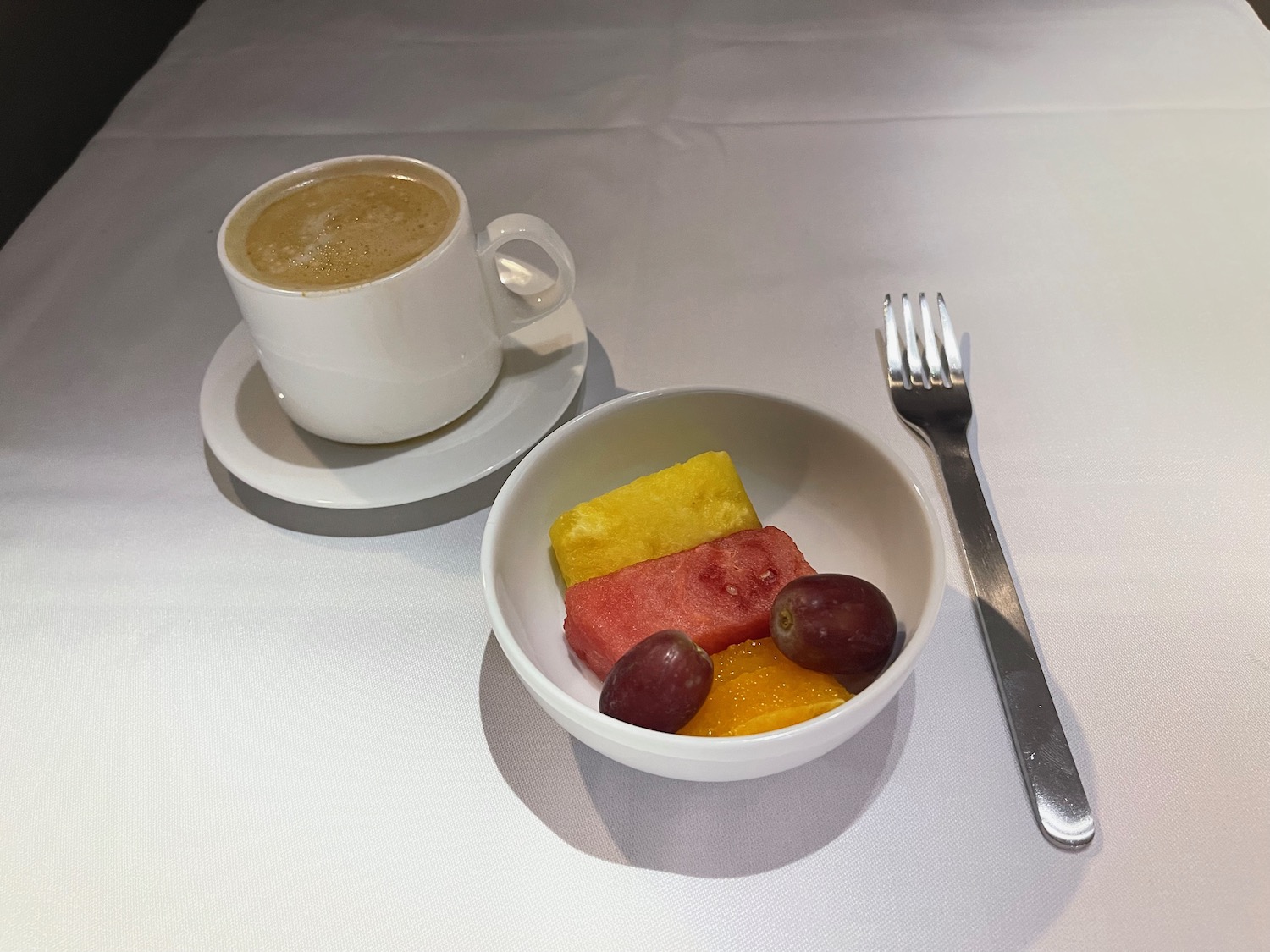 a bowl of fruit and a cup of coffee