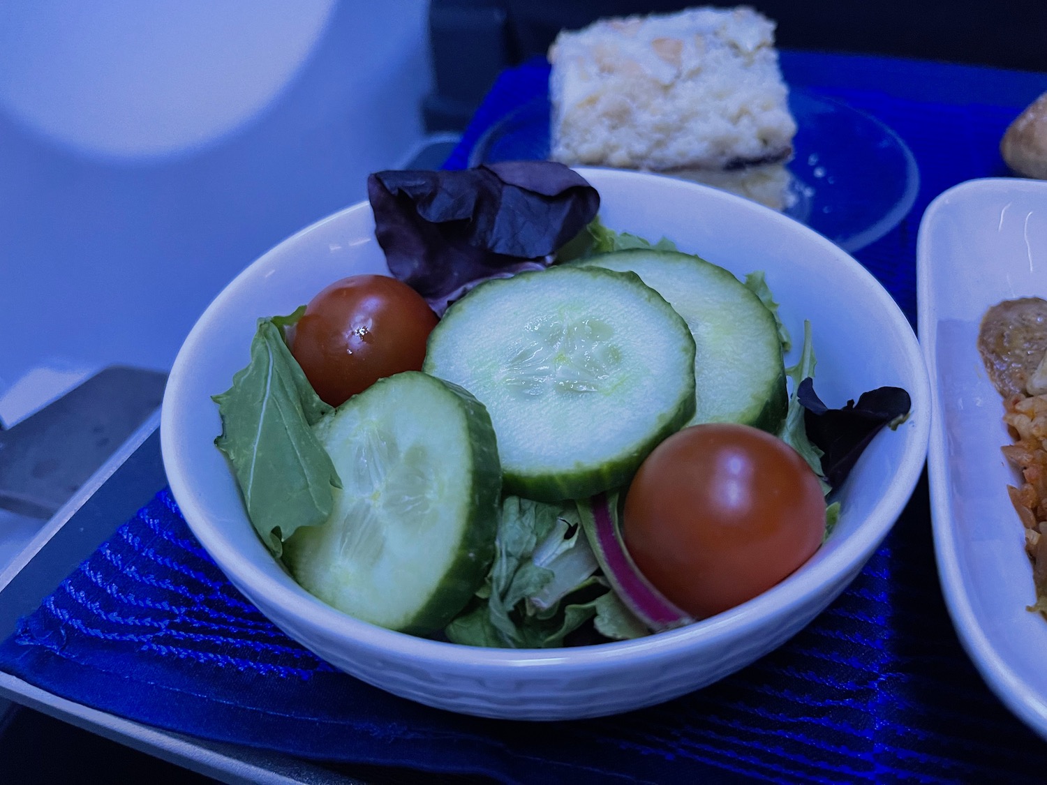a bowl of salad with cucumbers and tomatoes