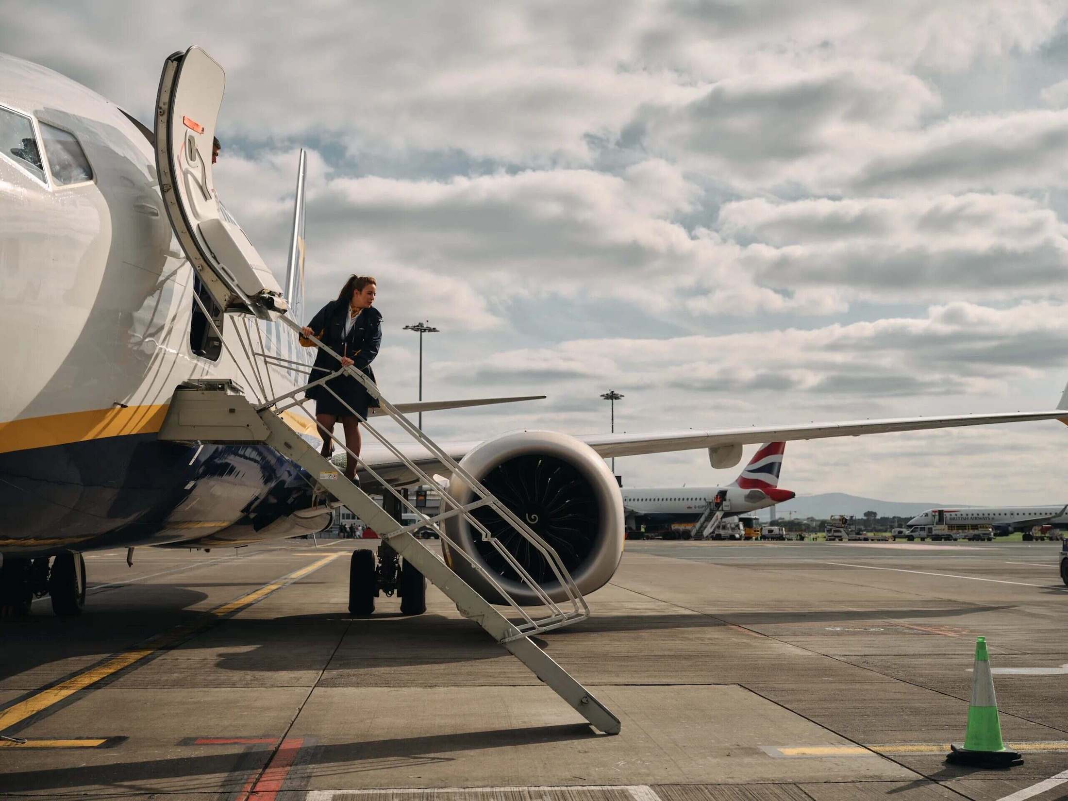 a woman walking up the stairs of an airplane