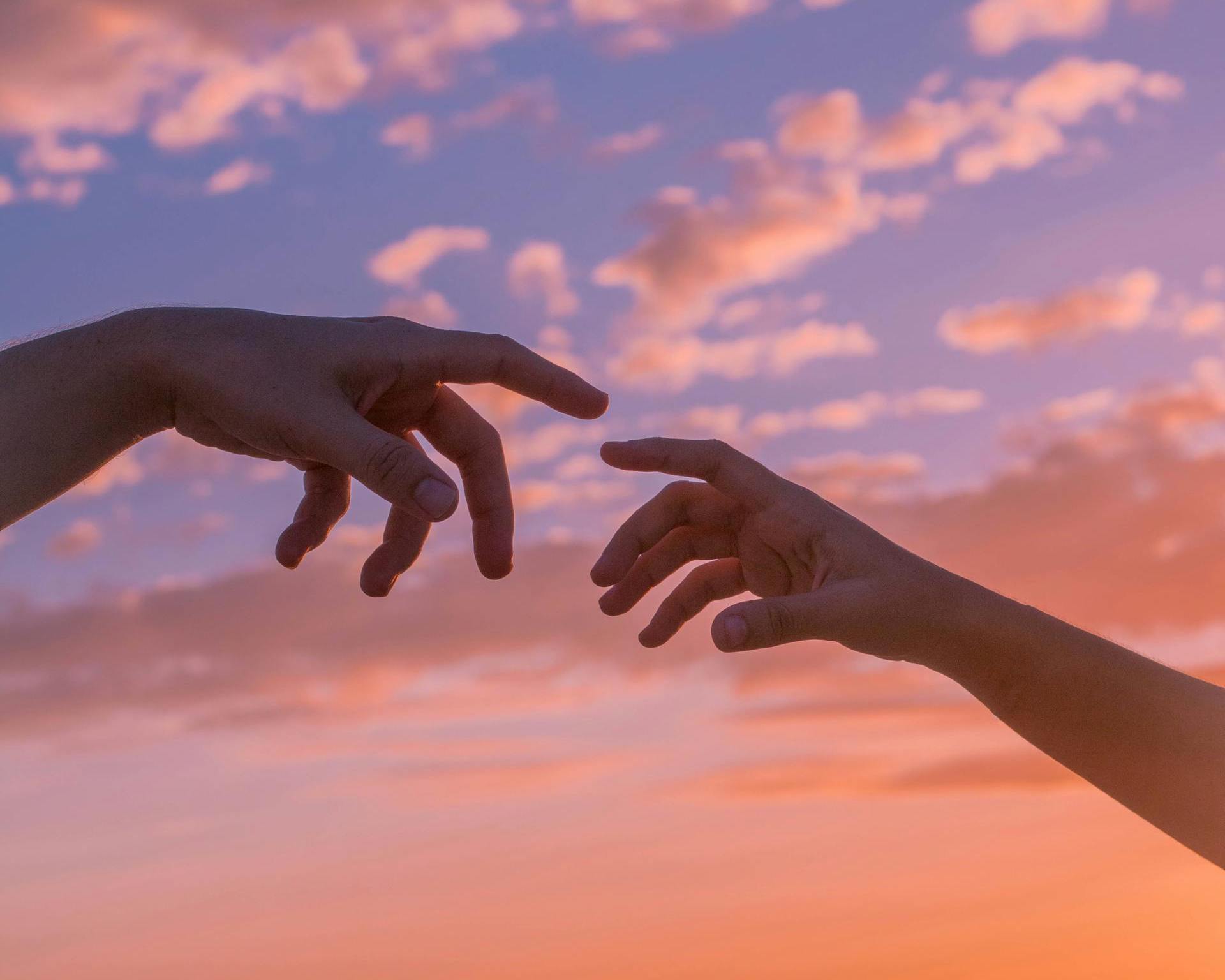 a close up of two hands reaching for each other