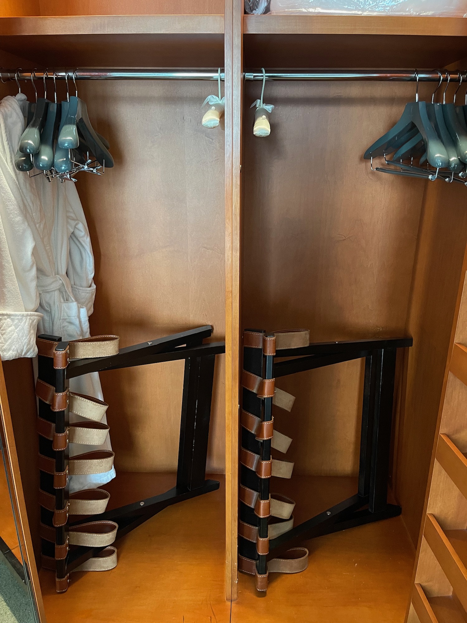 a closet with a pair of swingers and a white robe