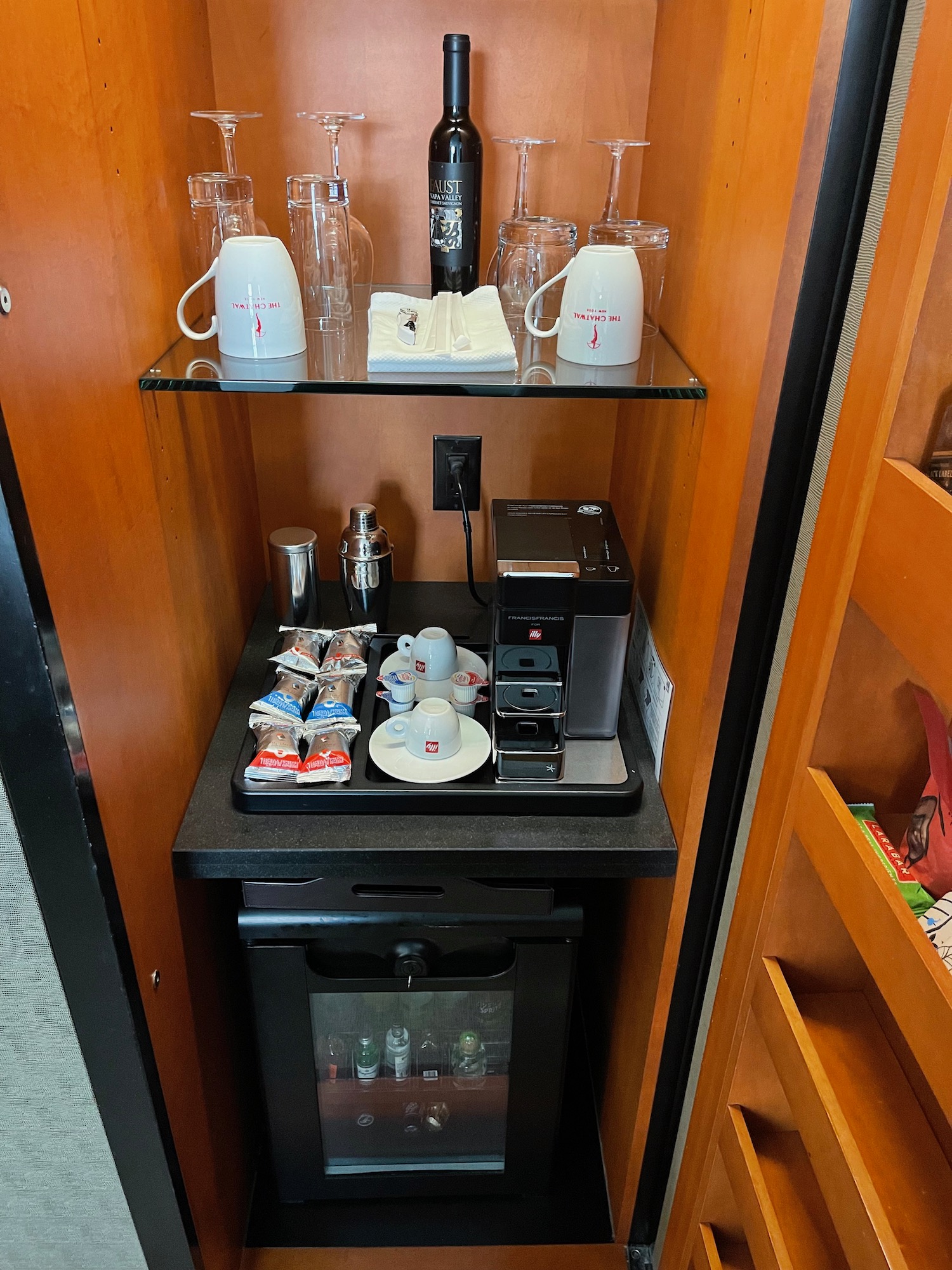 a small cabinet with a coffee machine and cups
