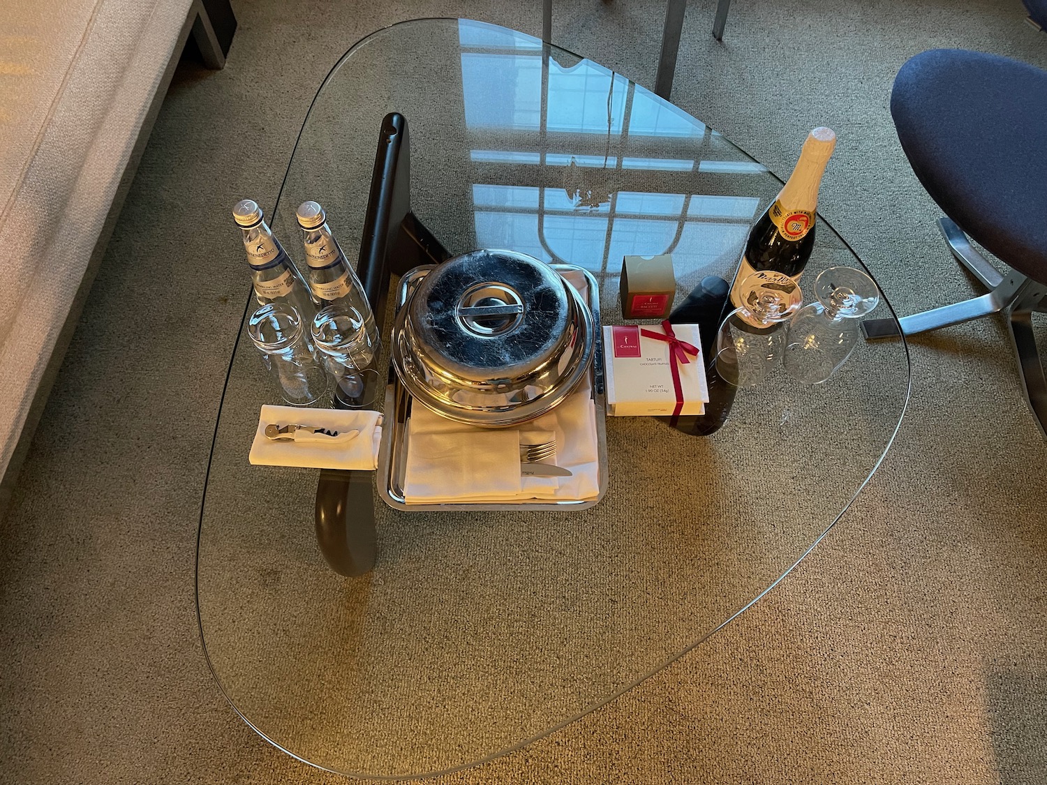 a glass table with bottles and a tray on it
