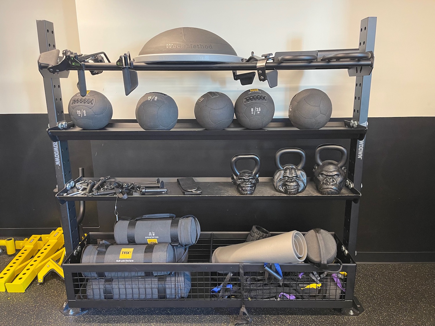 a shelf with weights and kettlebells