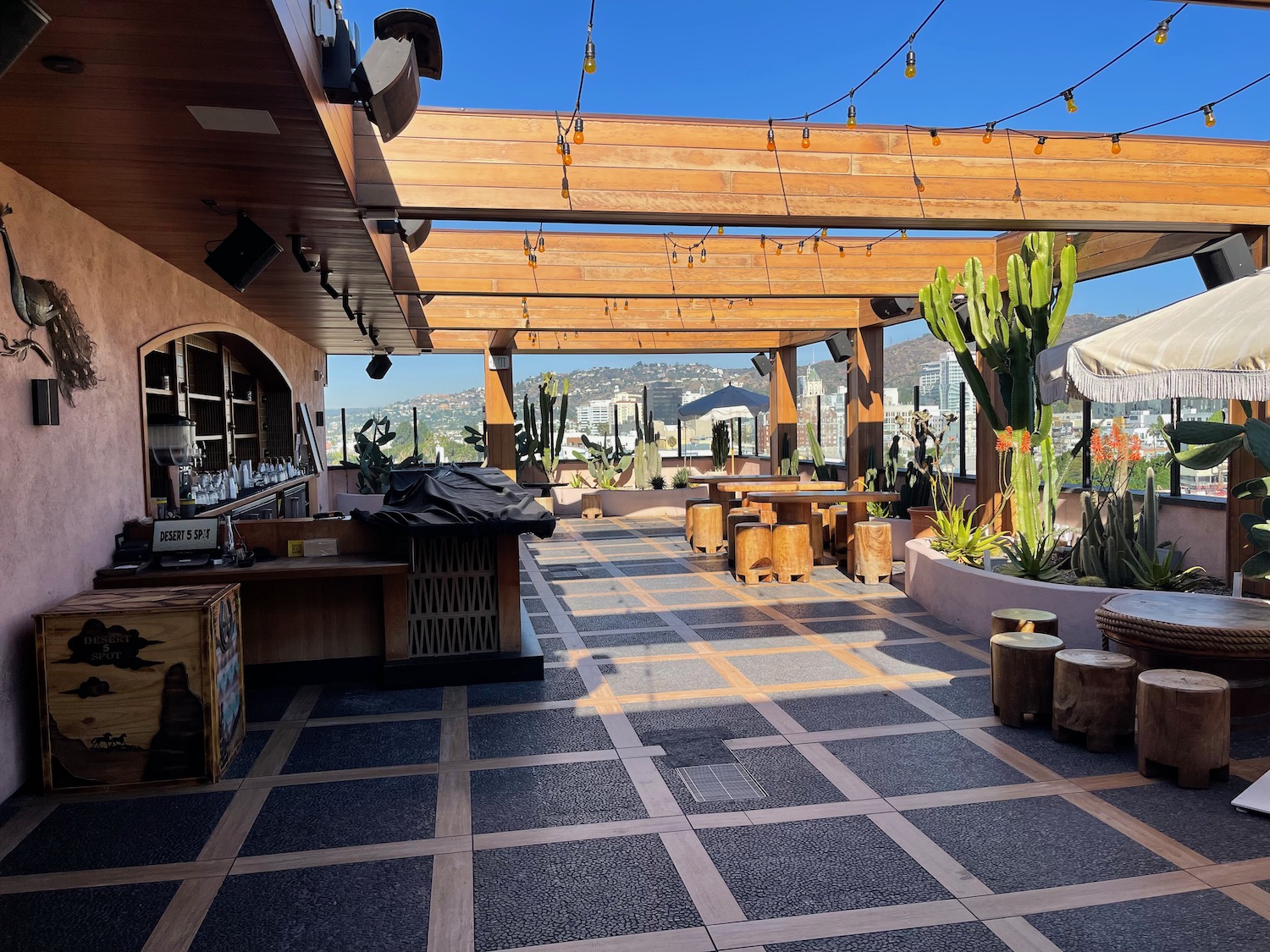 a patio with tables and chairs and cactuses