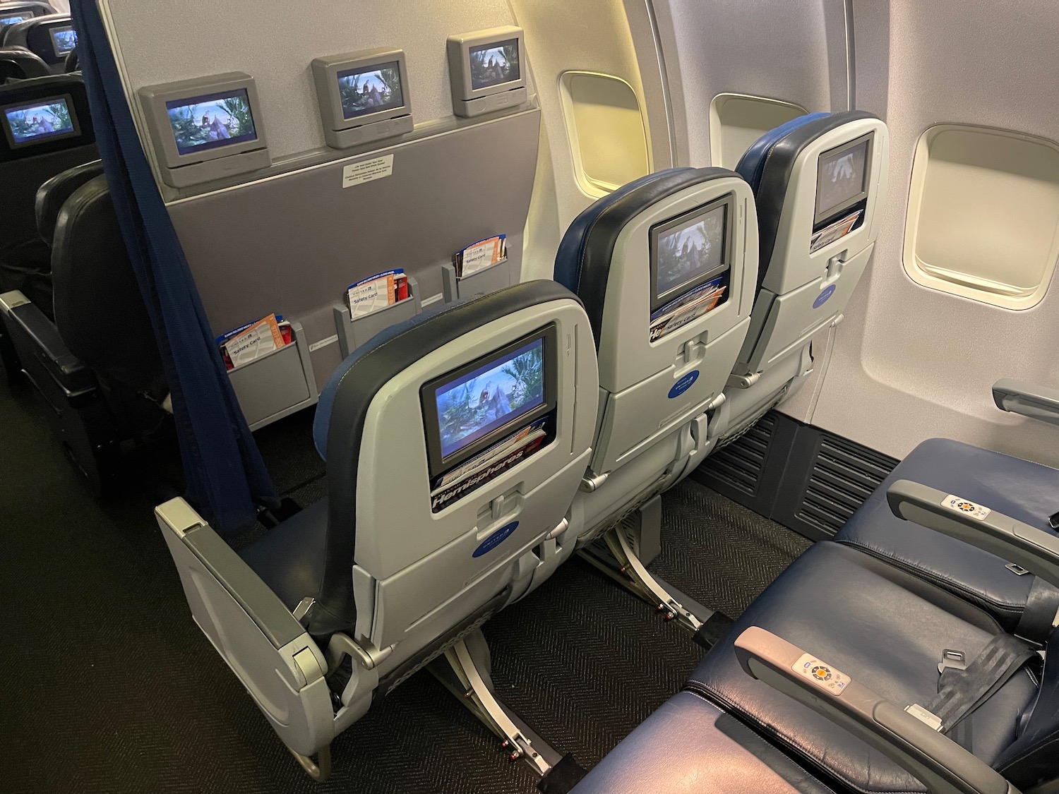 a row of seats with monitors on the back