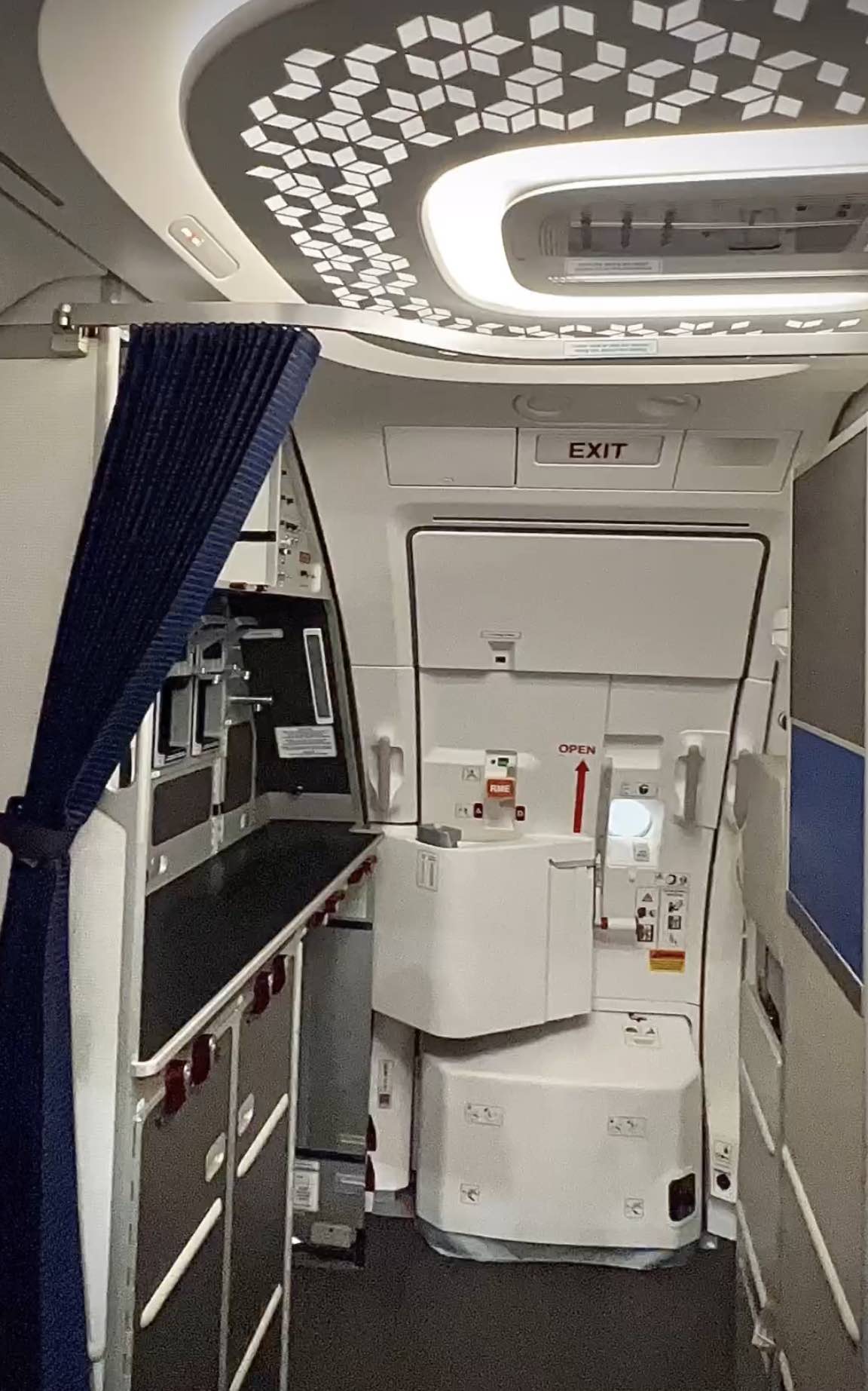 an airplane with a door open and a blue curtain