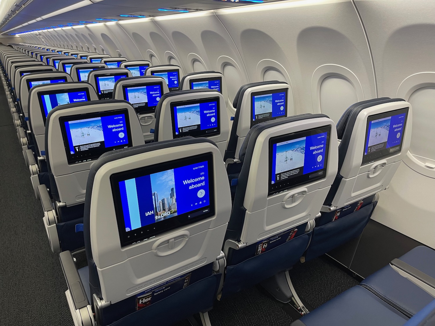 a row of seats with monitors on the side