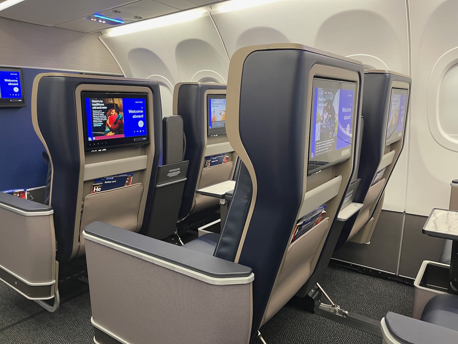 a row of seats with monitors on the side