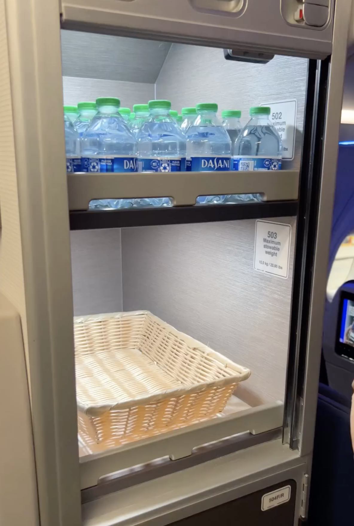 a shelf of water bottles and a basket