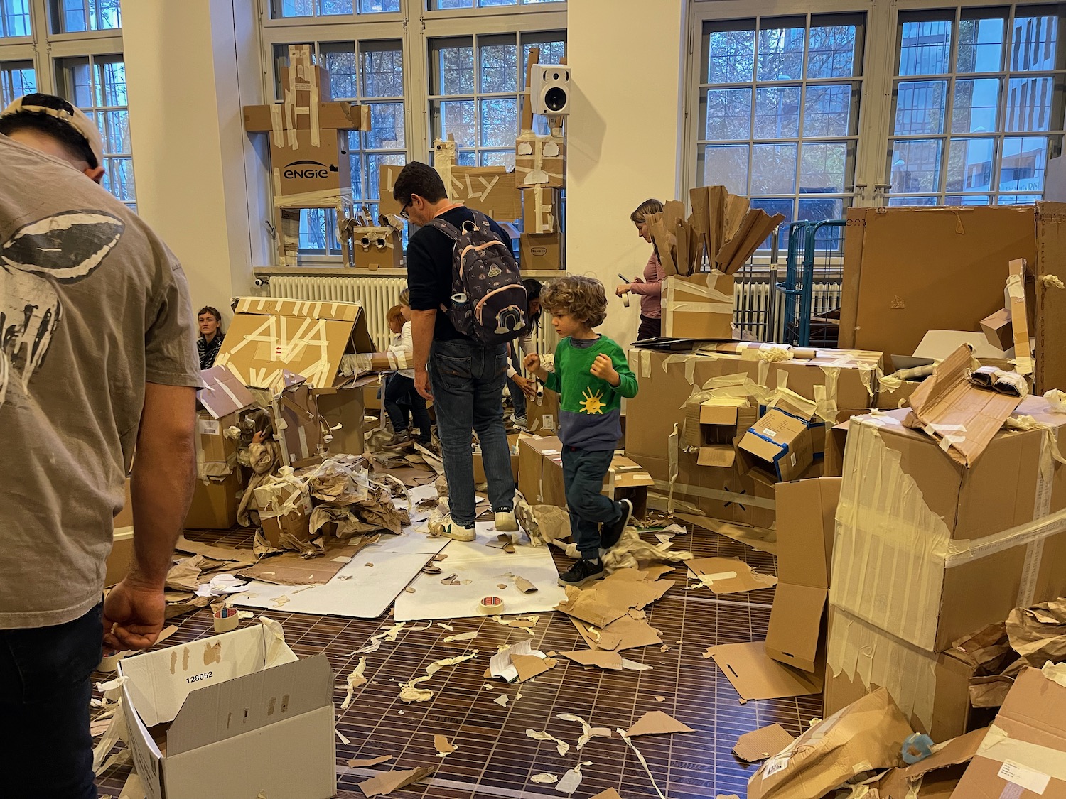 a group of people in a room with cardboard boxes