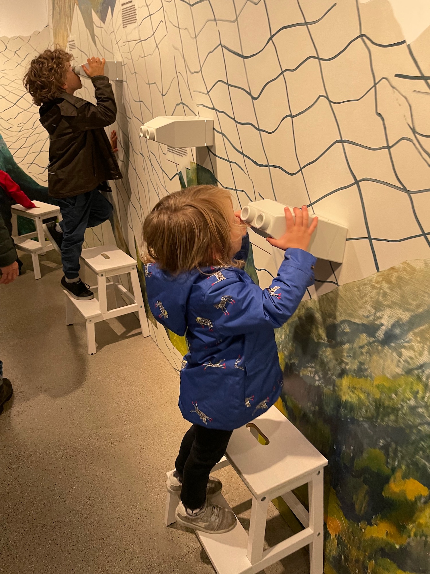 a group of children playing with a wall mural