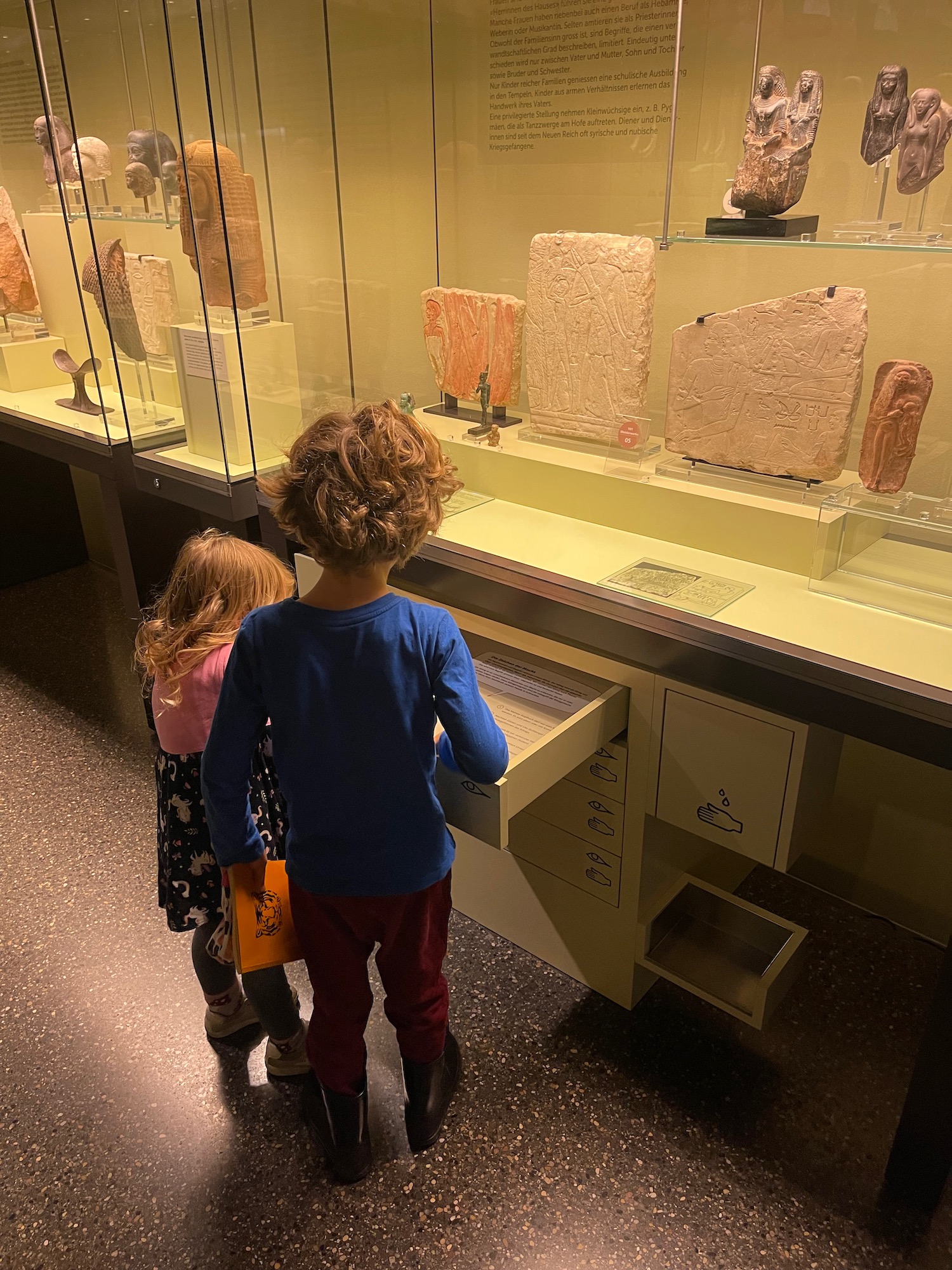 a boy and girl looking at a display case