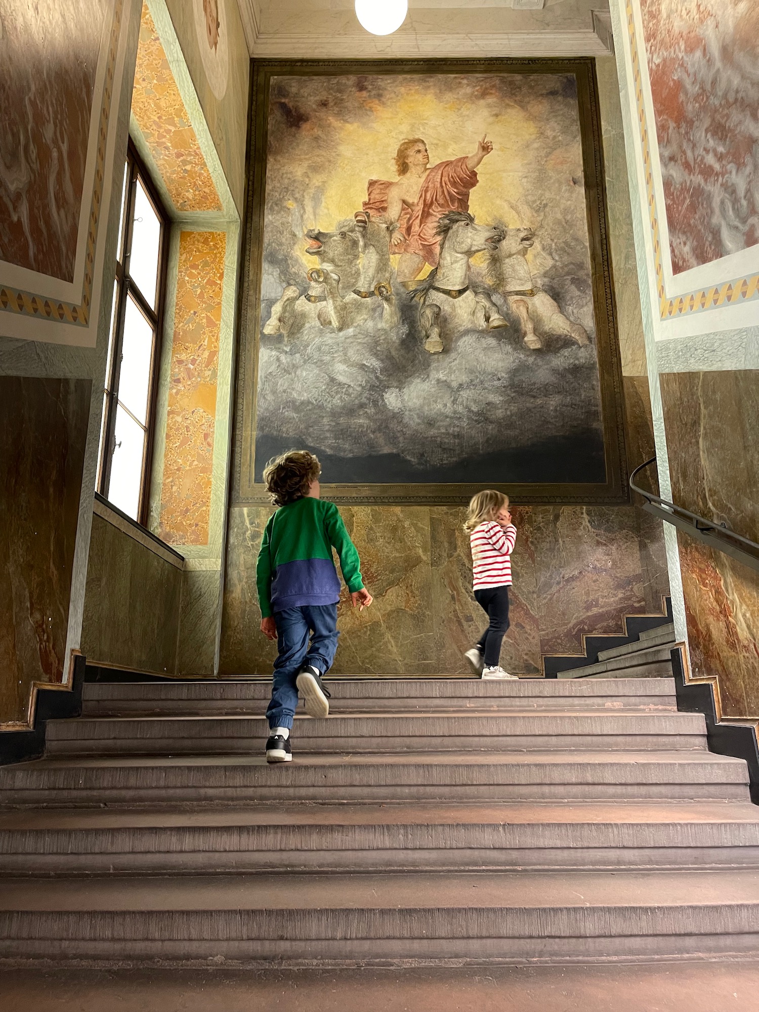 two children walking up stairs in a building