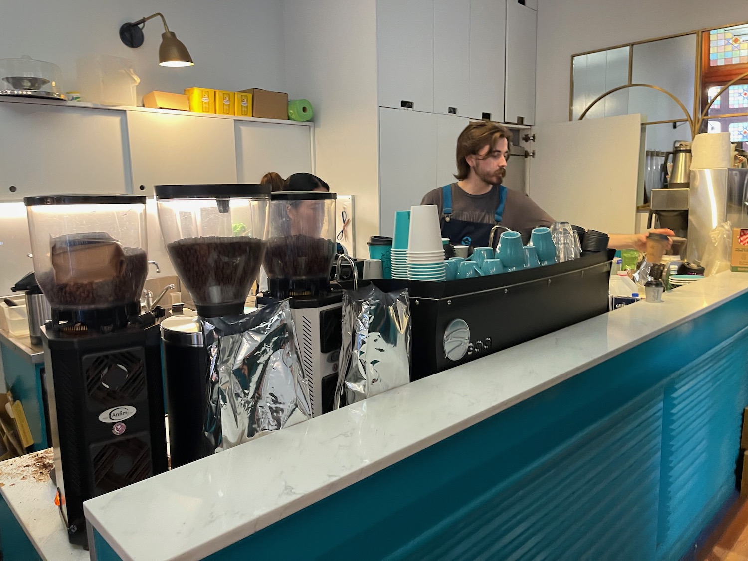 a man standing behind a counter with a coffee machine