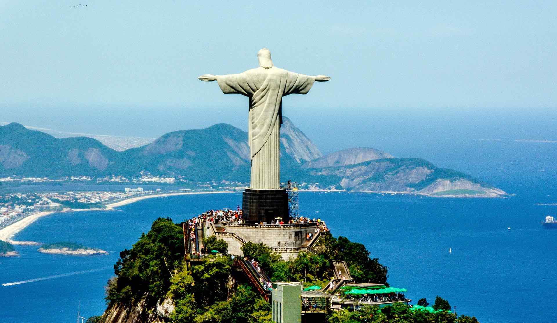 a statue of a man on a hill with people around it