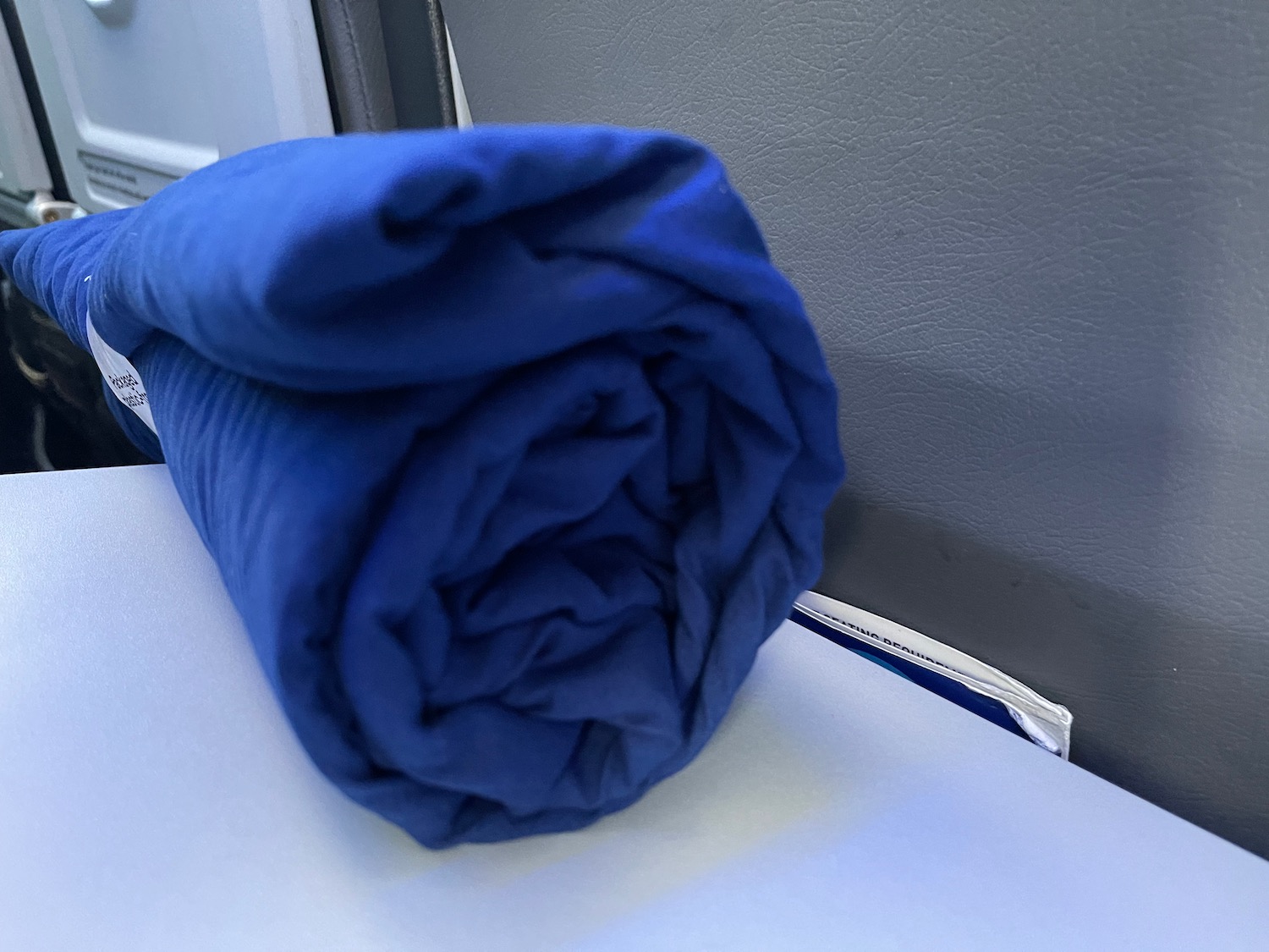 a blue blanket rolled up on a white surface