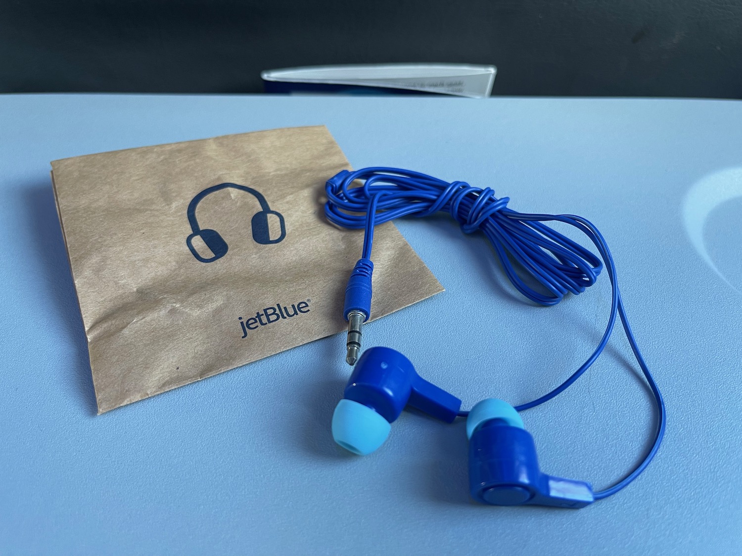 a blue earbuds and a paper bag