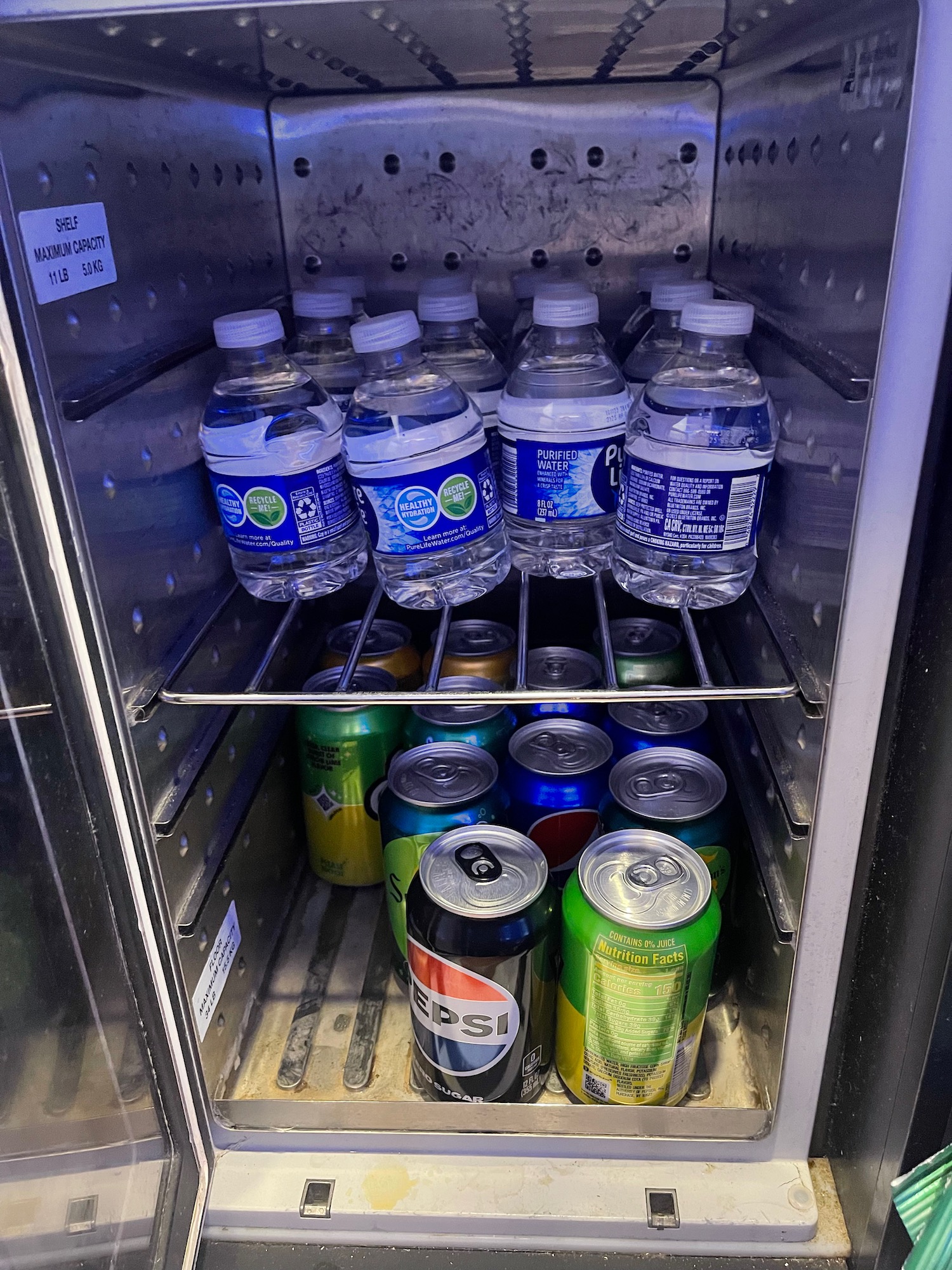 a group of cans and bottles in a refrigerator