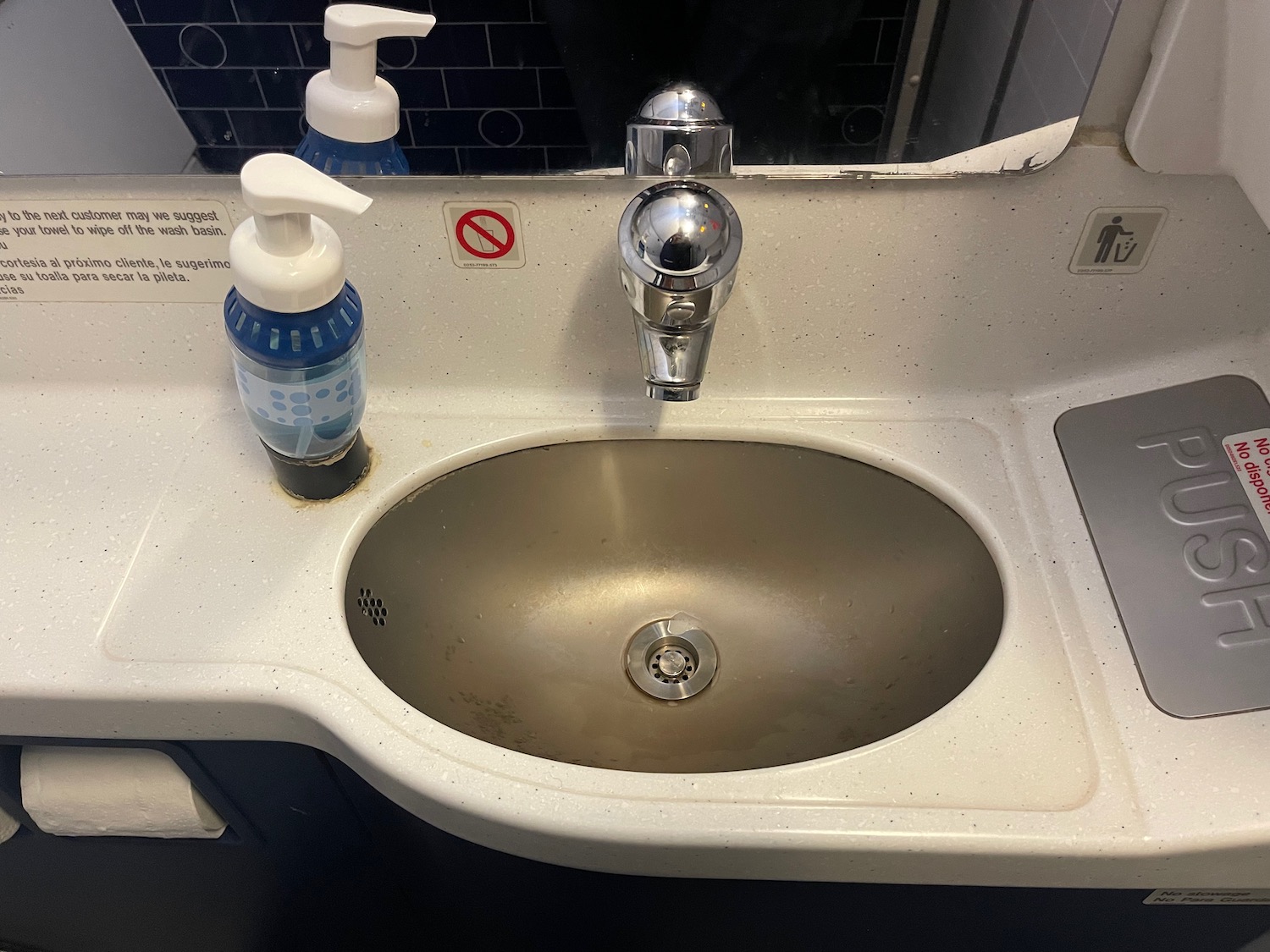 a sink with soap dispenser and a bottle of liquid