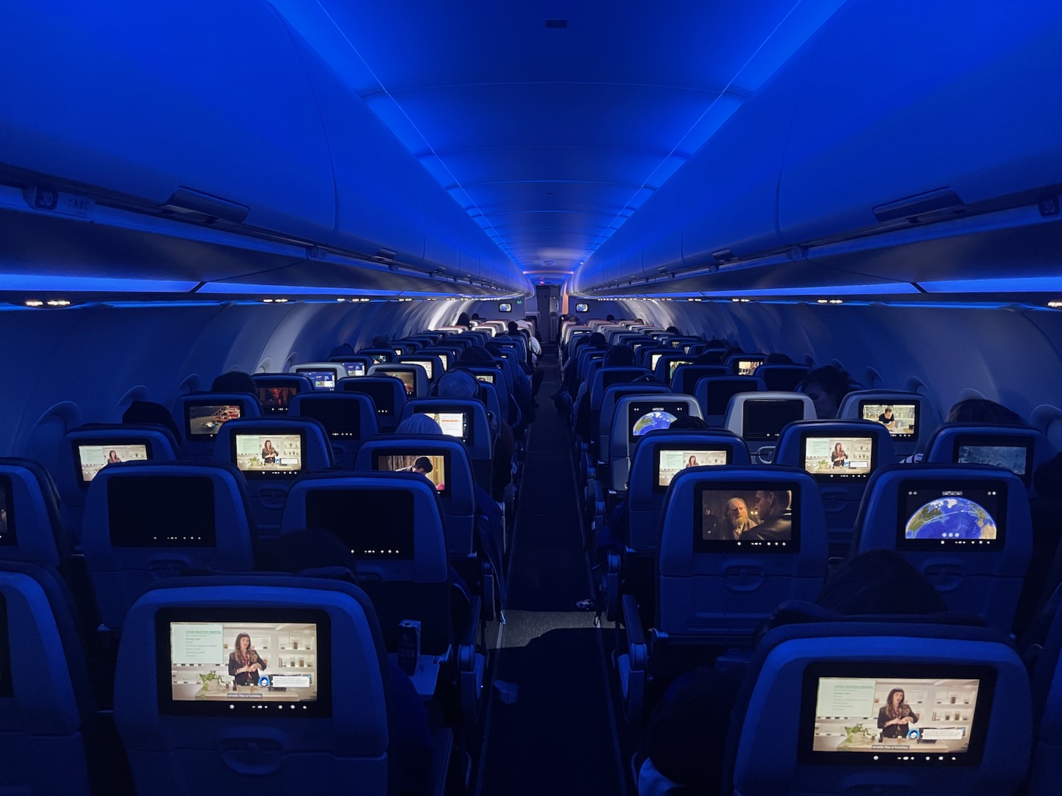 an airplane with rows of seats with monitors on the back